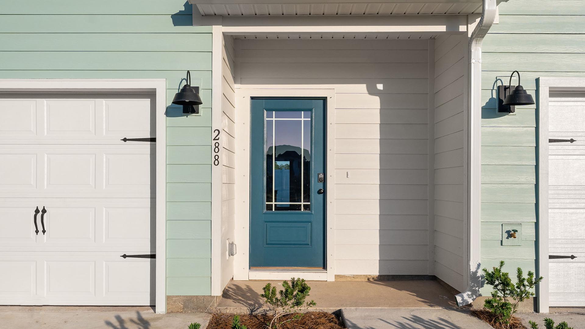 The entry to the Palm townhome has a glass prairie style door