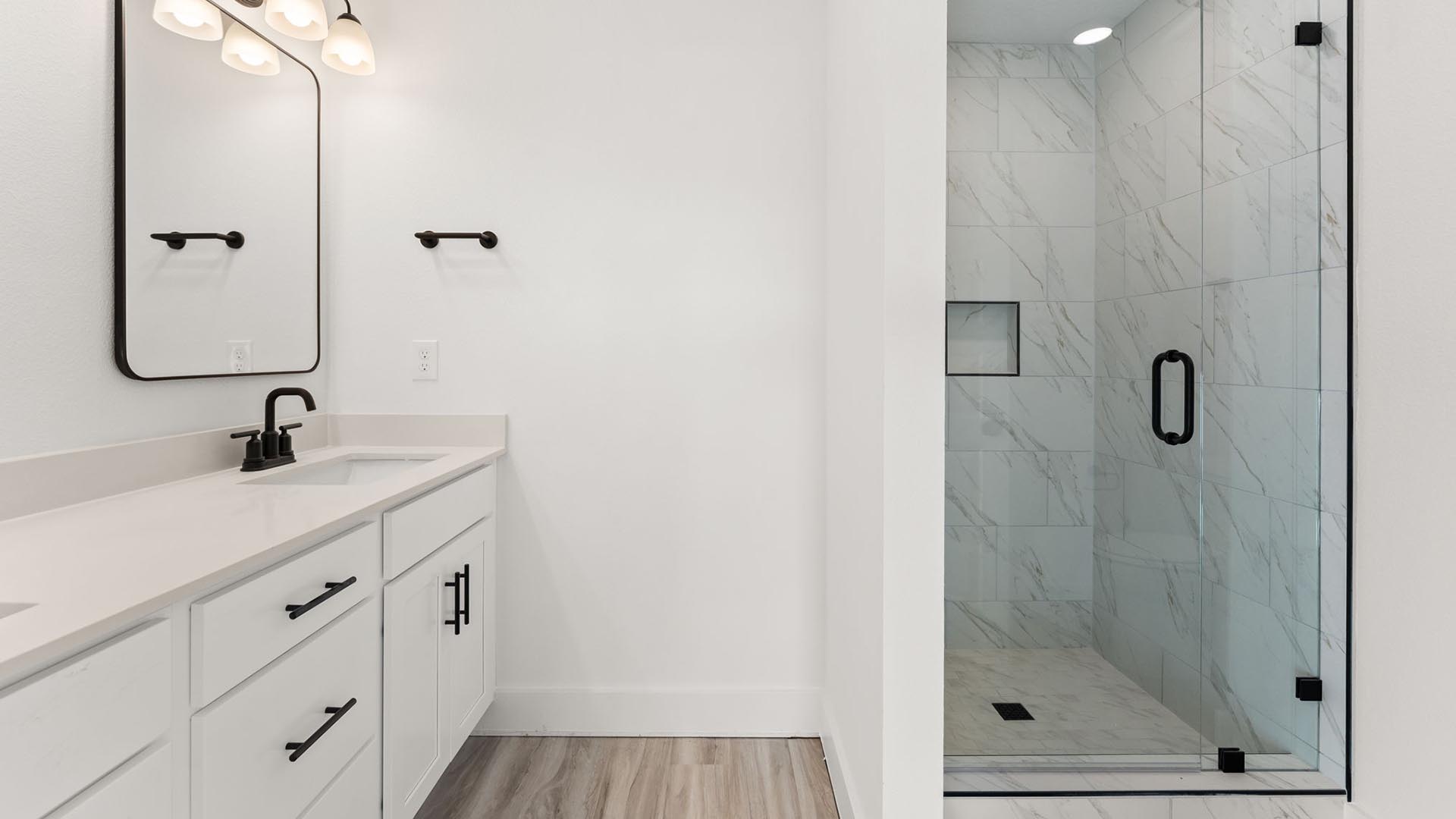 The primary bathroom has a tile shower with glass enclosure
