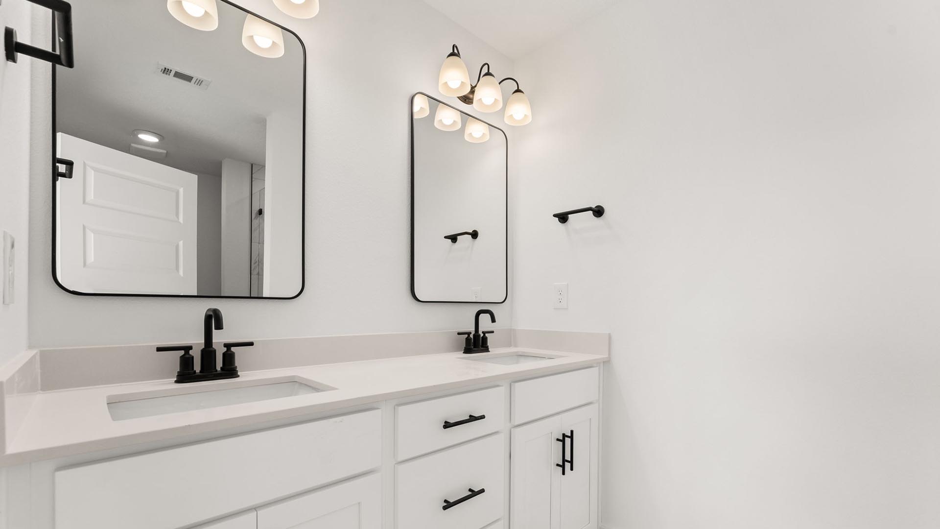 The primary bathroom has a dual sink vanity with lower cabinetry and drawers for storage