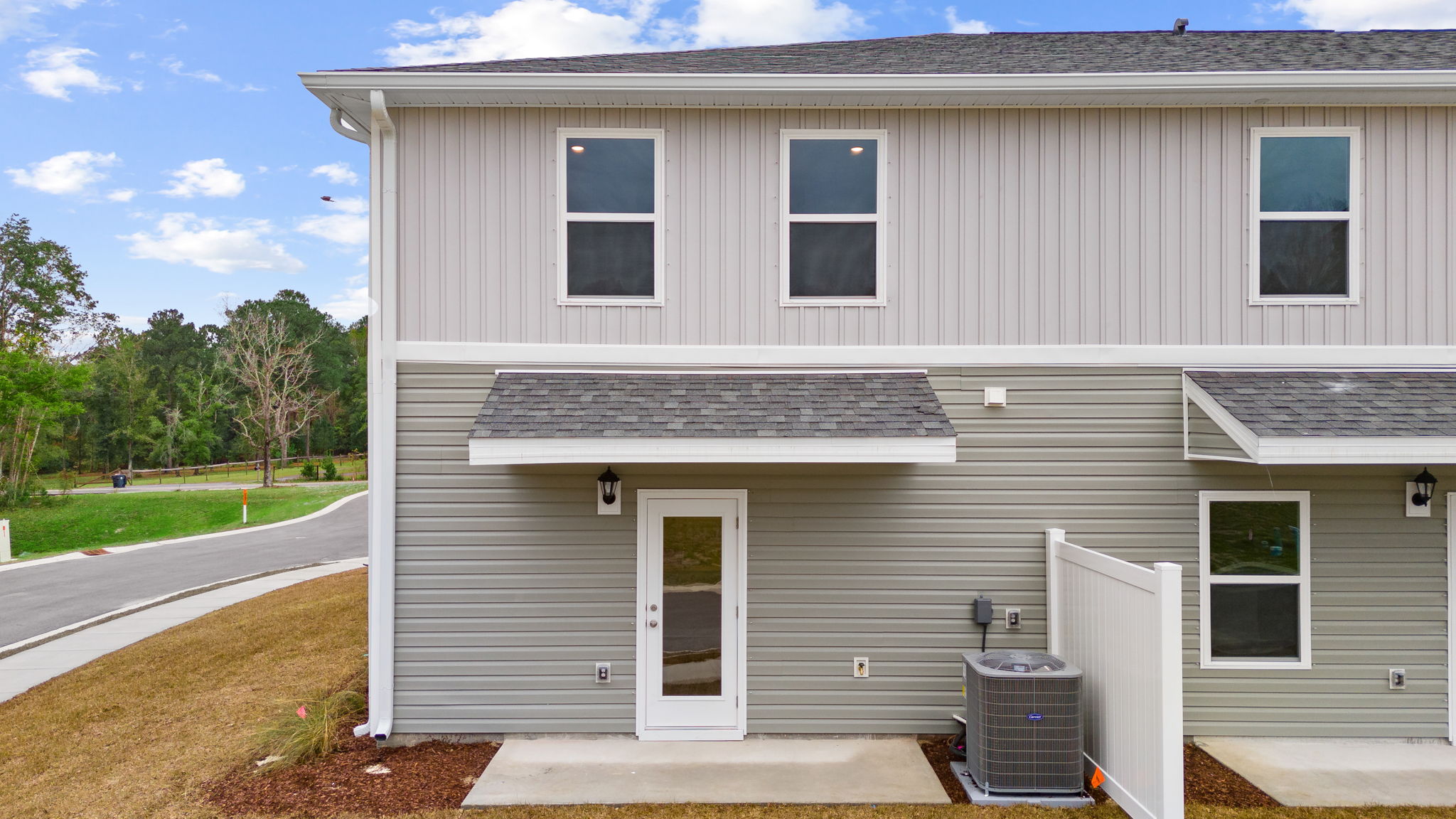 The back of the townhome has a patio and partition between units.
