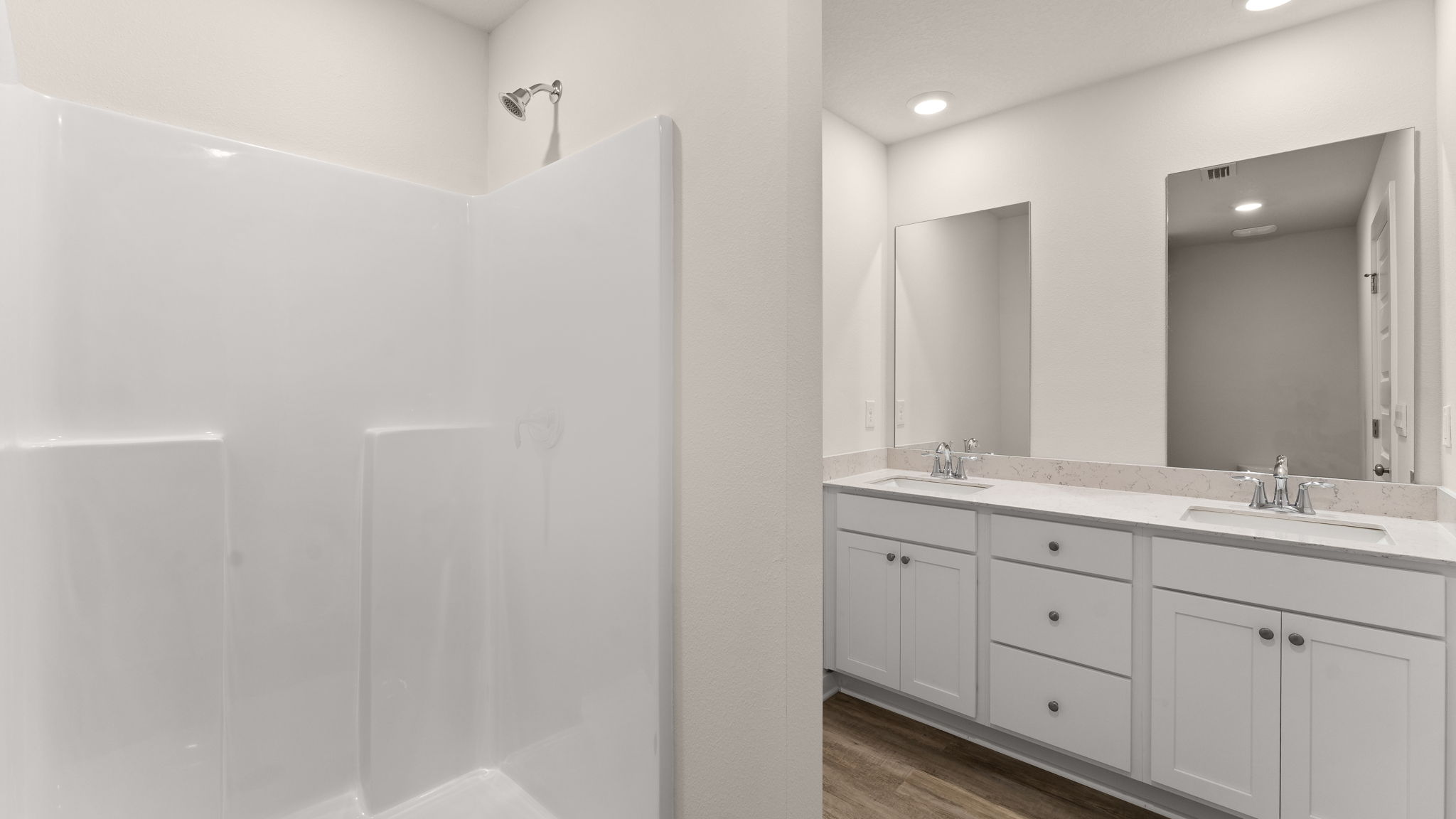 The primary bathroom has a dual sink vanity with quartz countertops