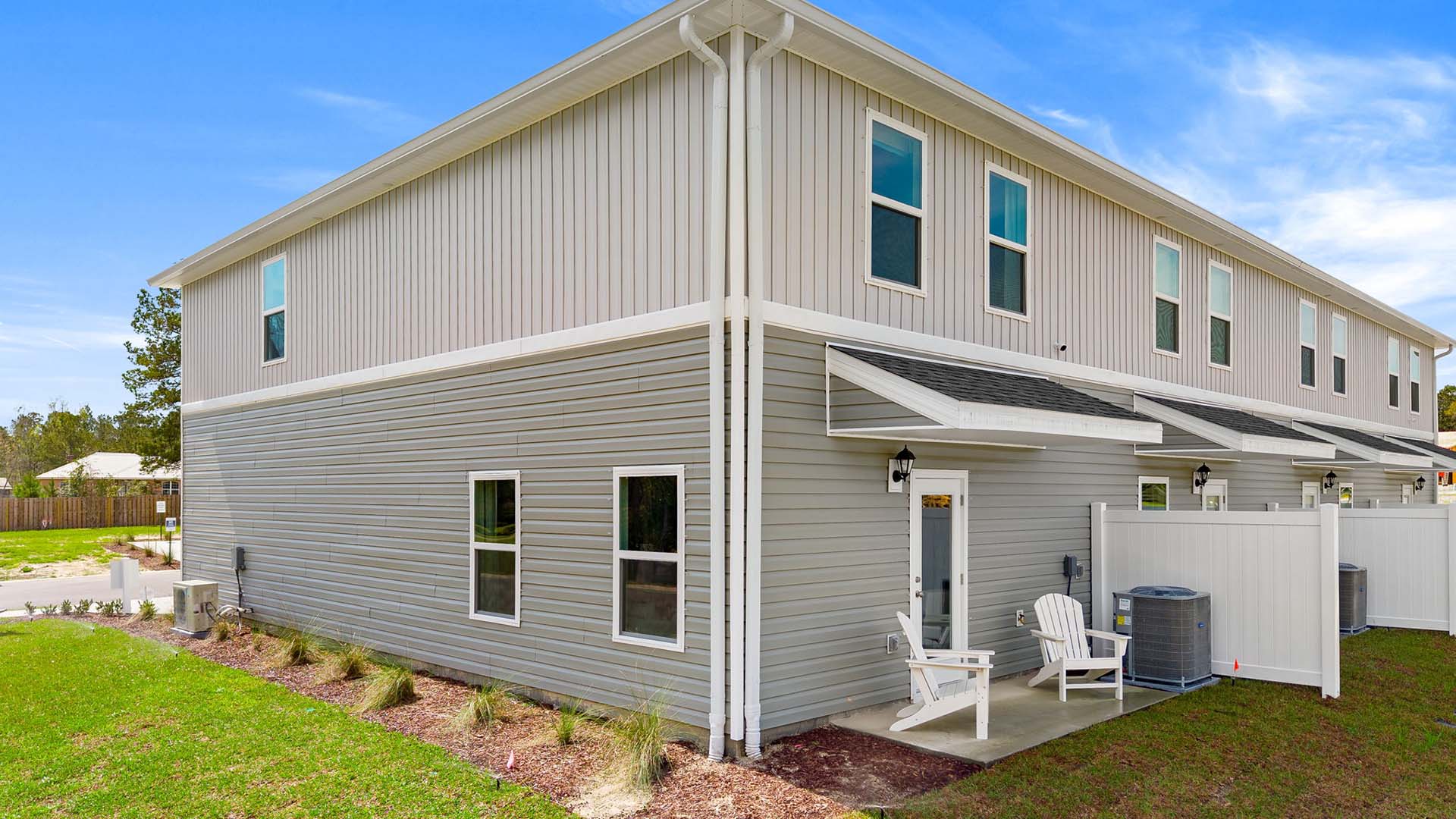 The back of the townhome has a patio and partition between units.