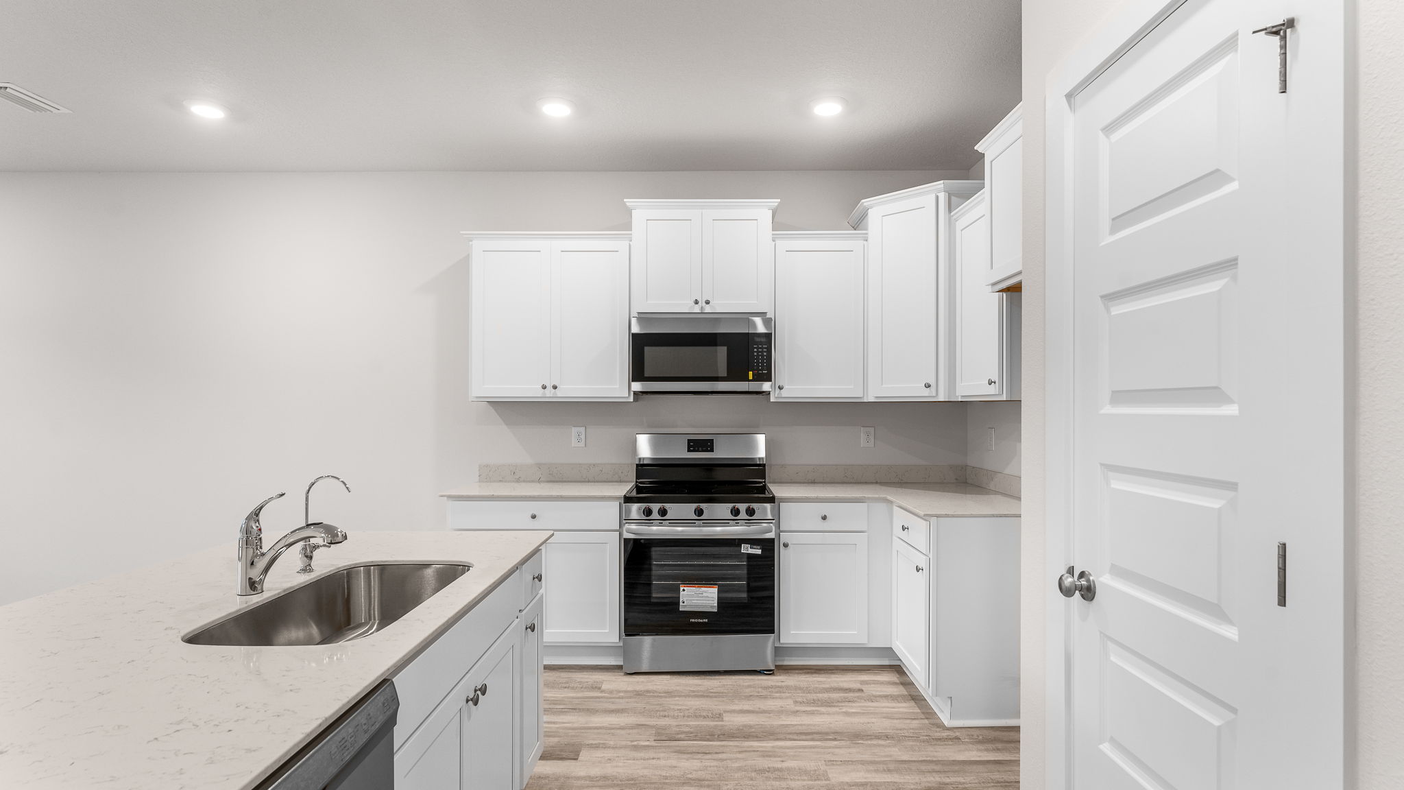 The kitchen has quartz countertops and white cabinetry