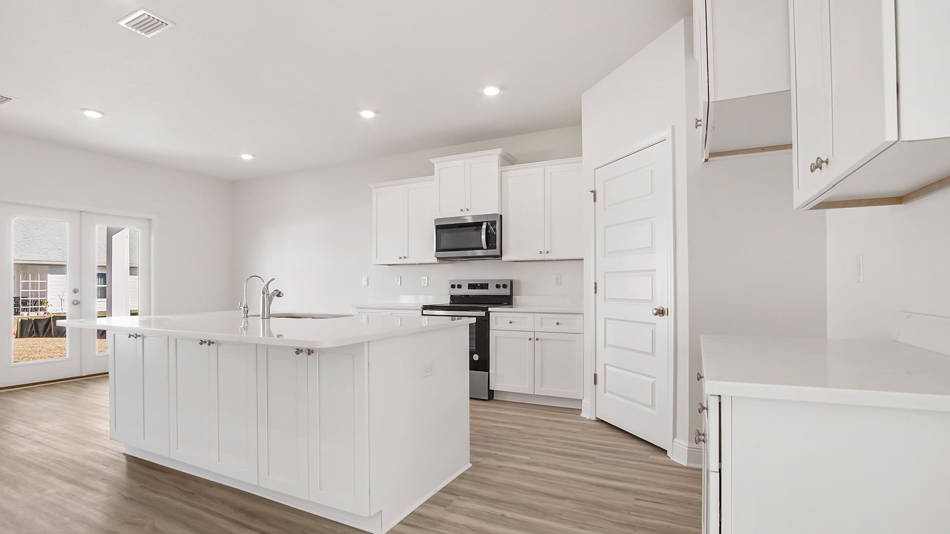 Kitchen features a center island and beautiful white cabinetry