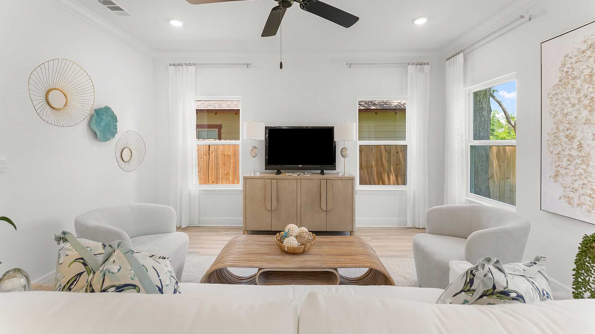 The living area has a ceiling fan and access to the back patio