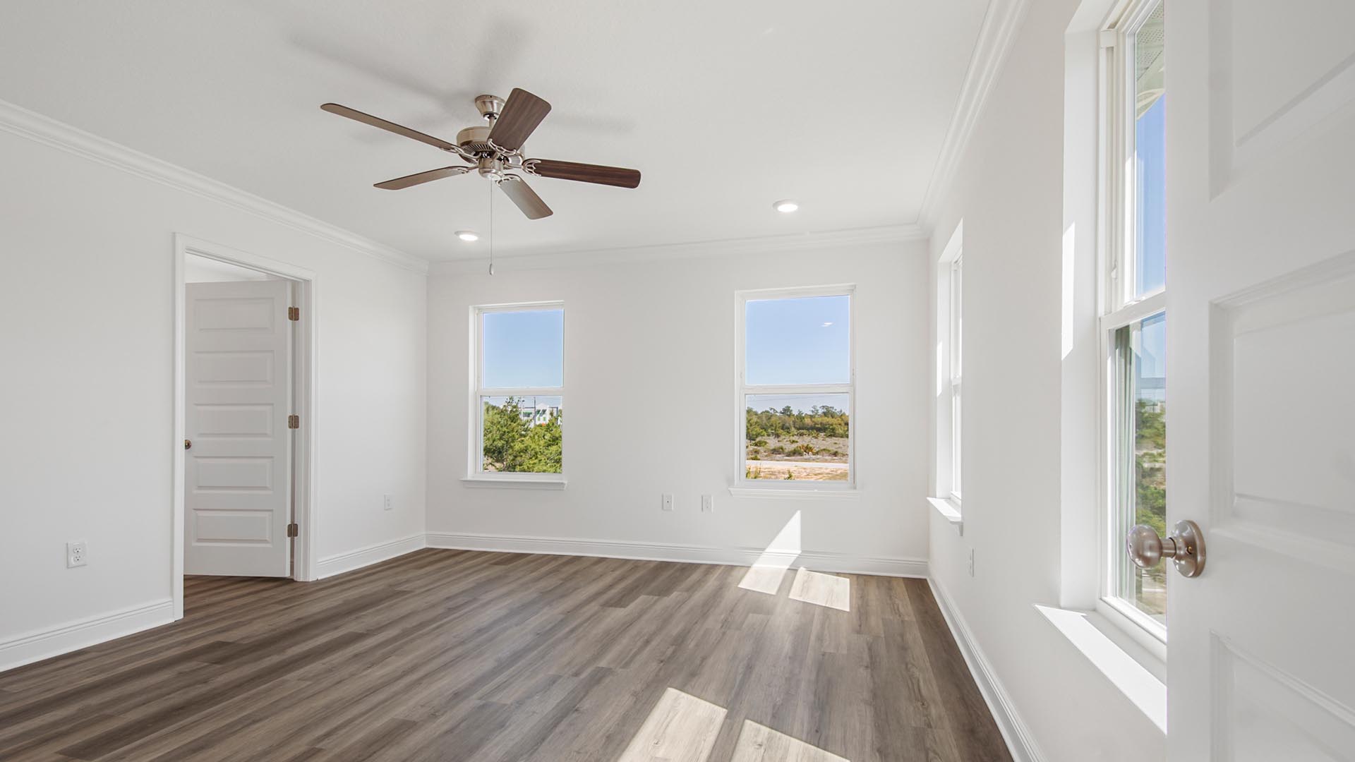 The primary bedroom has an open feel with windows and overlooks the back of the home