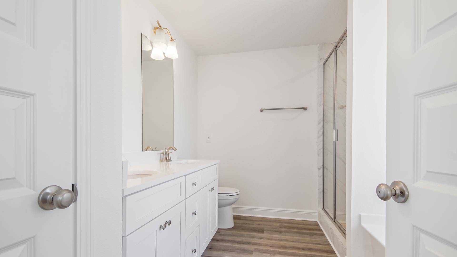 The primary bathroom has lower cabinetry and a dual sink vanity