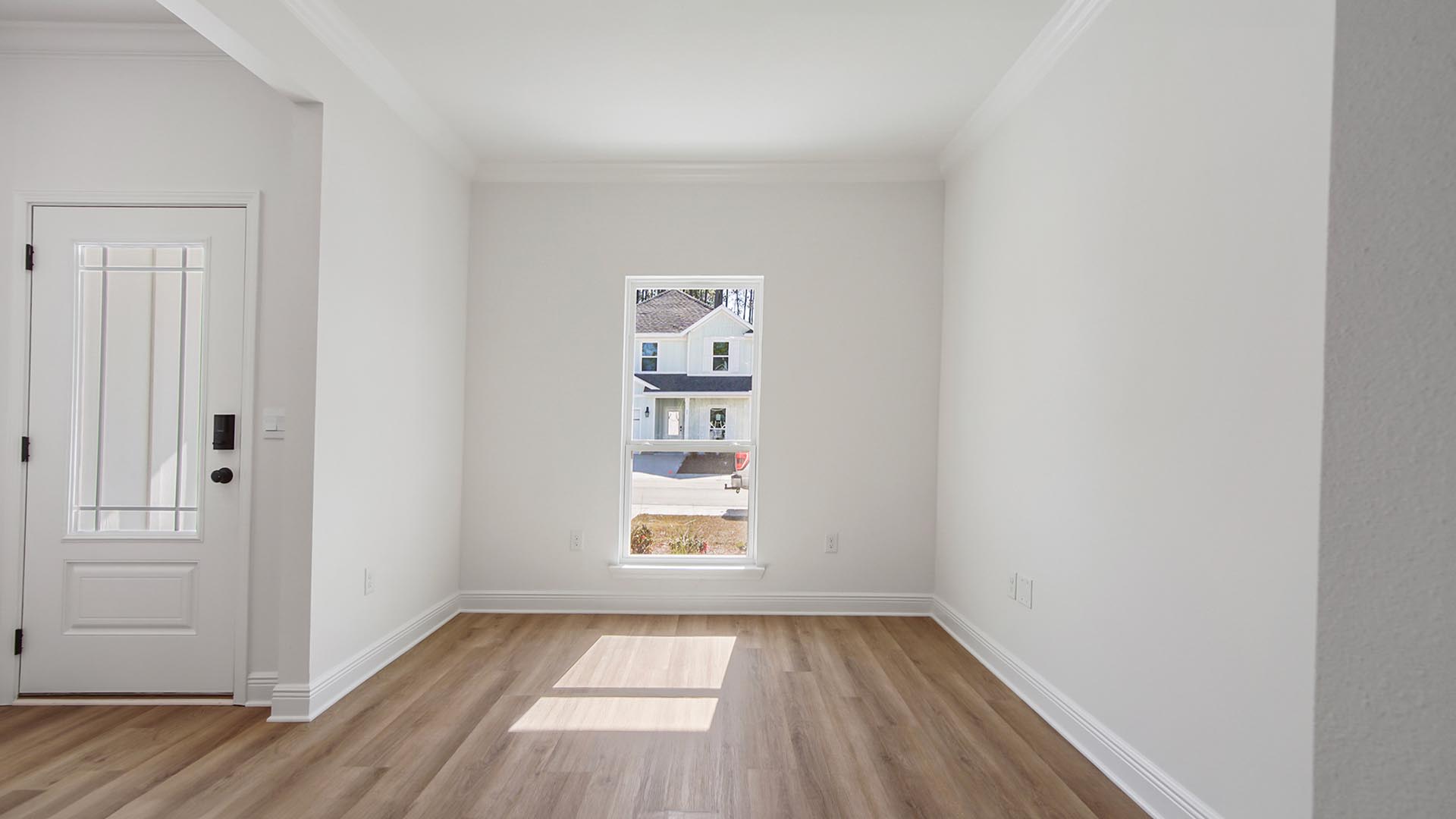 The dining room features EVP flooring and windows allowing for natural light
