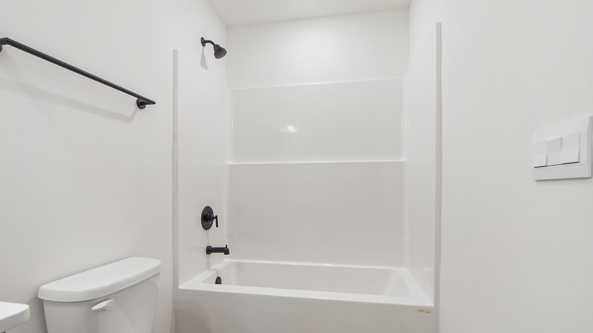 The shared hall bath has a shower tub combination