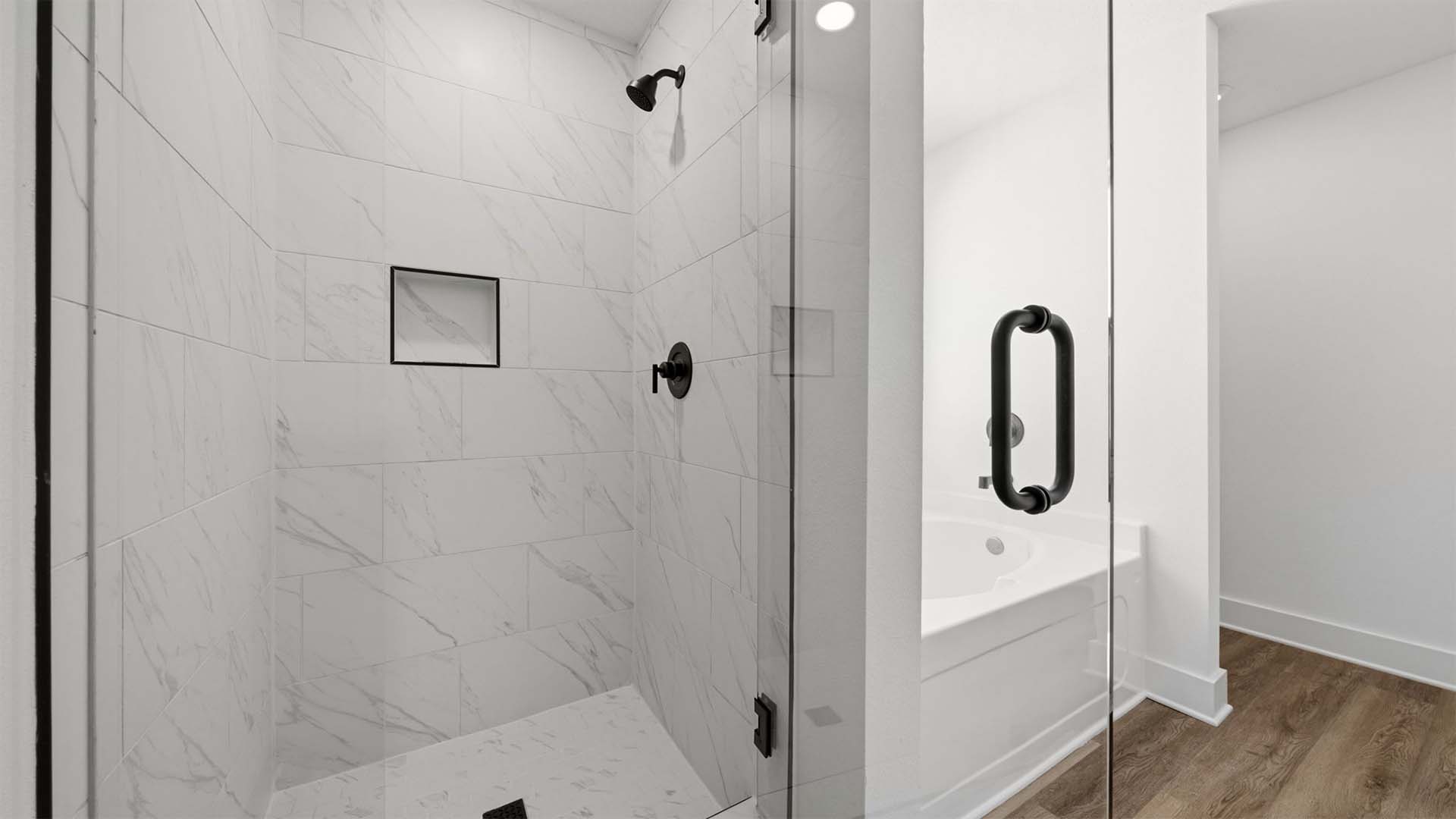 The primary bath shower has a frameless glass enclosure