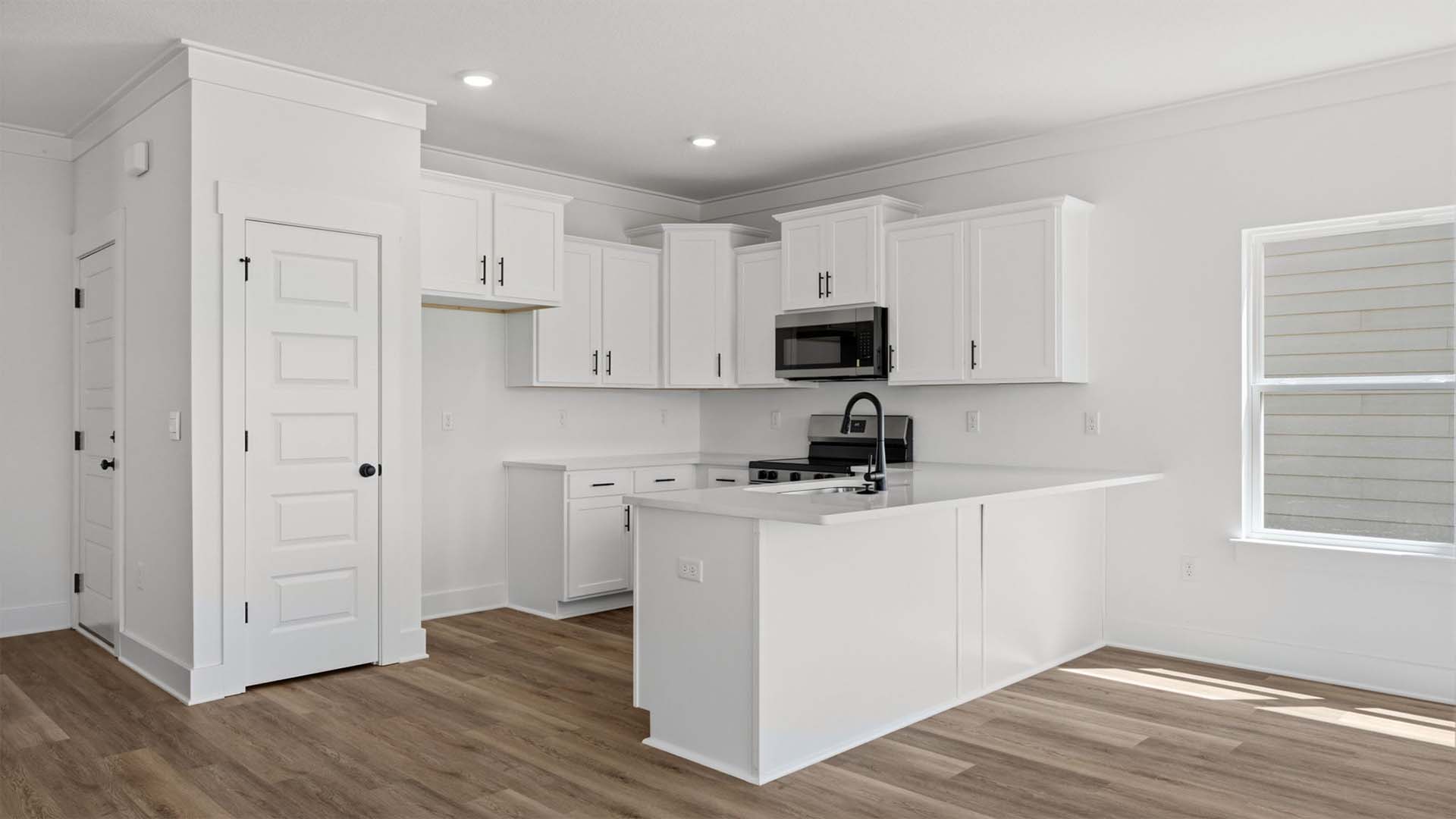 Upper cabinetry in white with soft close doors are complemented by a tile backsplash
