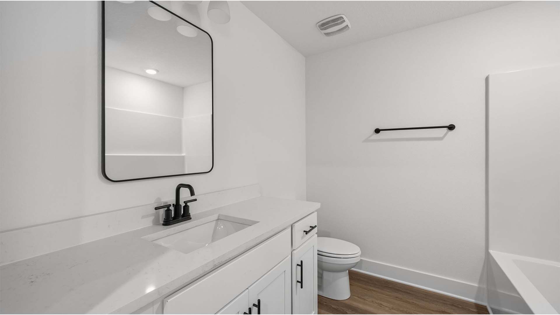 The guest bedrooms share a full bathroom with single vanity adorned with quartz countertop and lower cabinetry for storage