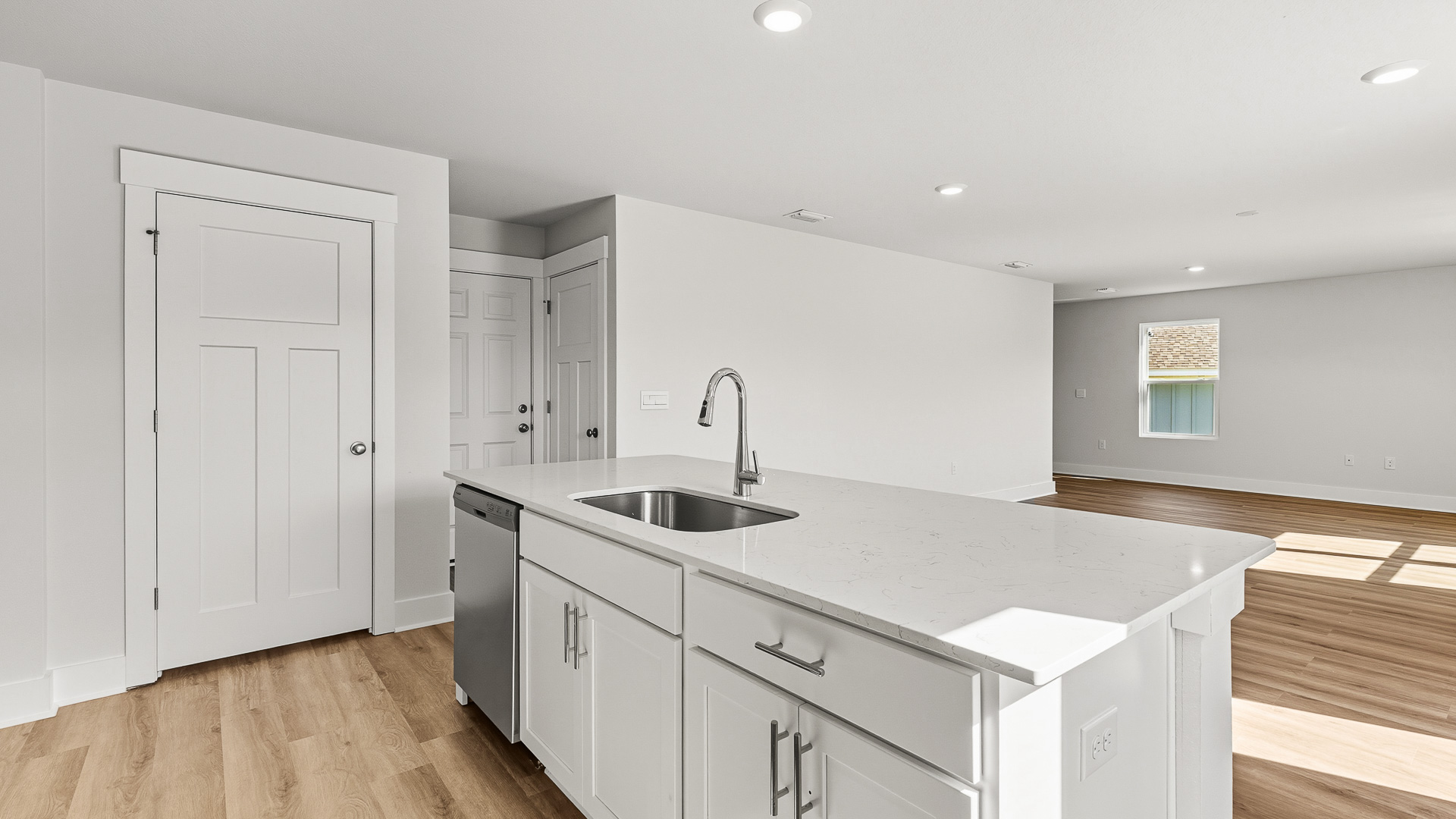 The kitchen island has lower cabinetry for storage and the dishwasher and sink for easy meal clean up