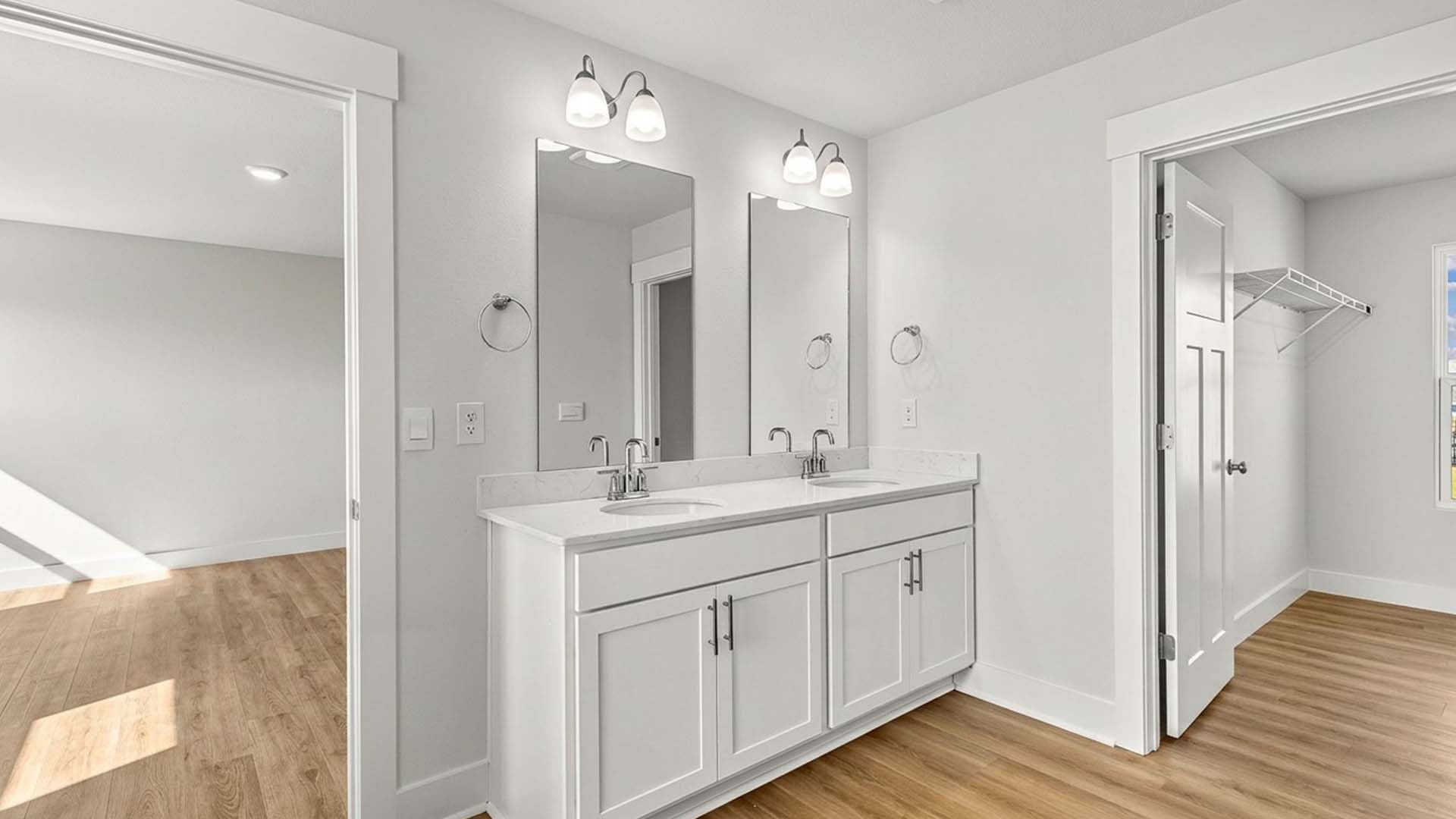The primary bath has a dual sink vanity and lower cabinetry