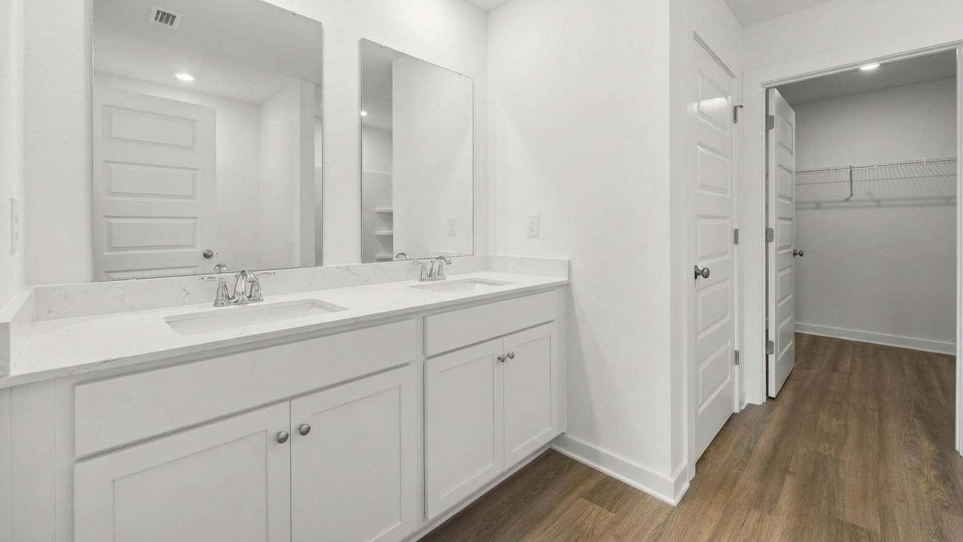 The primary bathroom has quartz countertops that complement the white lower cabinetry