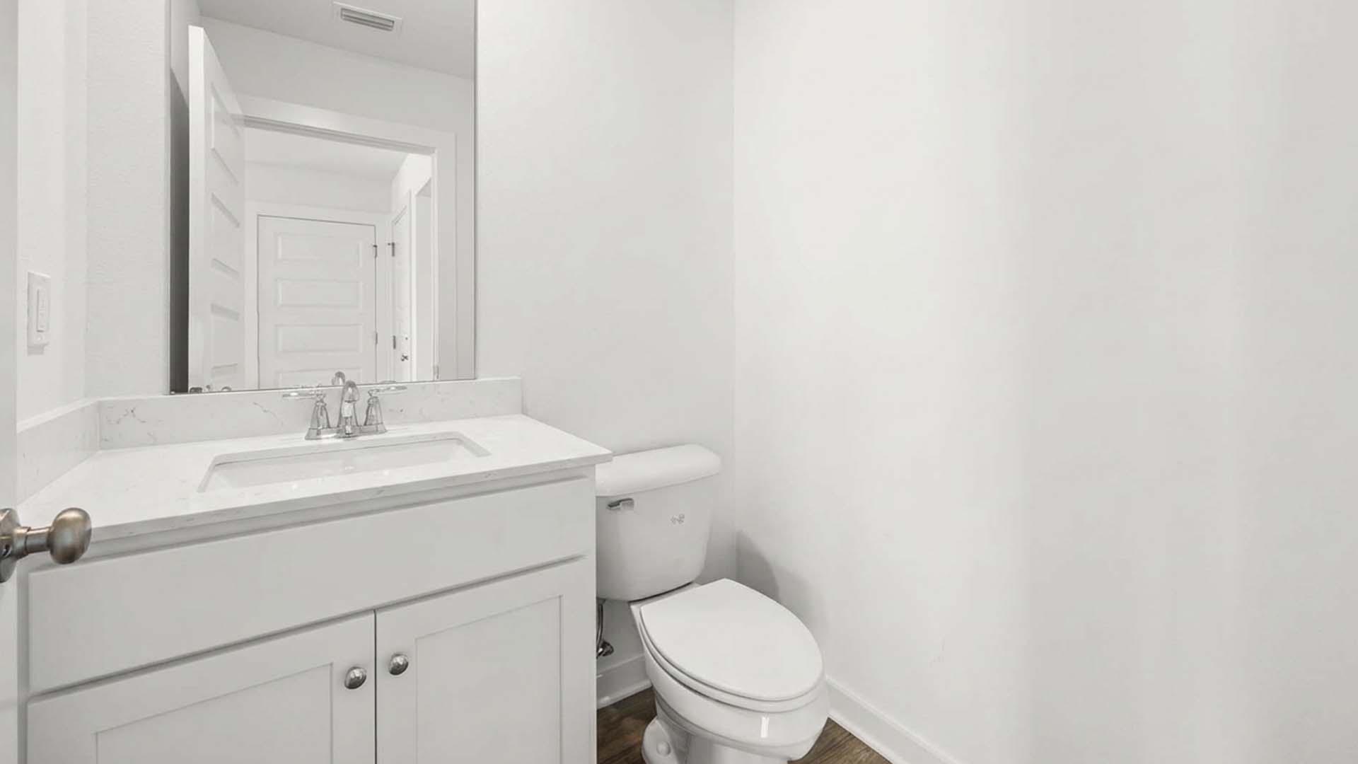 Downstairs there is a half bath with quartz countertops