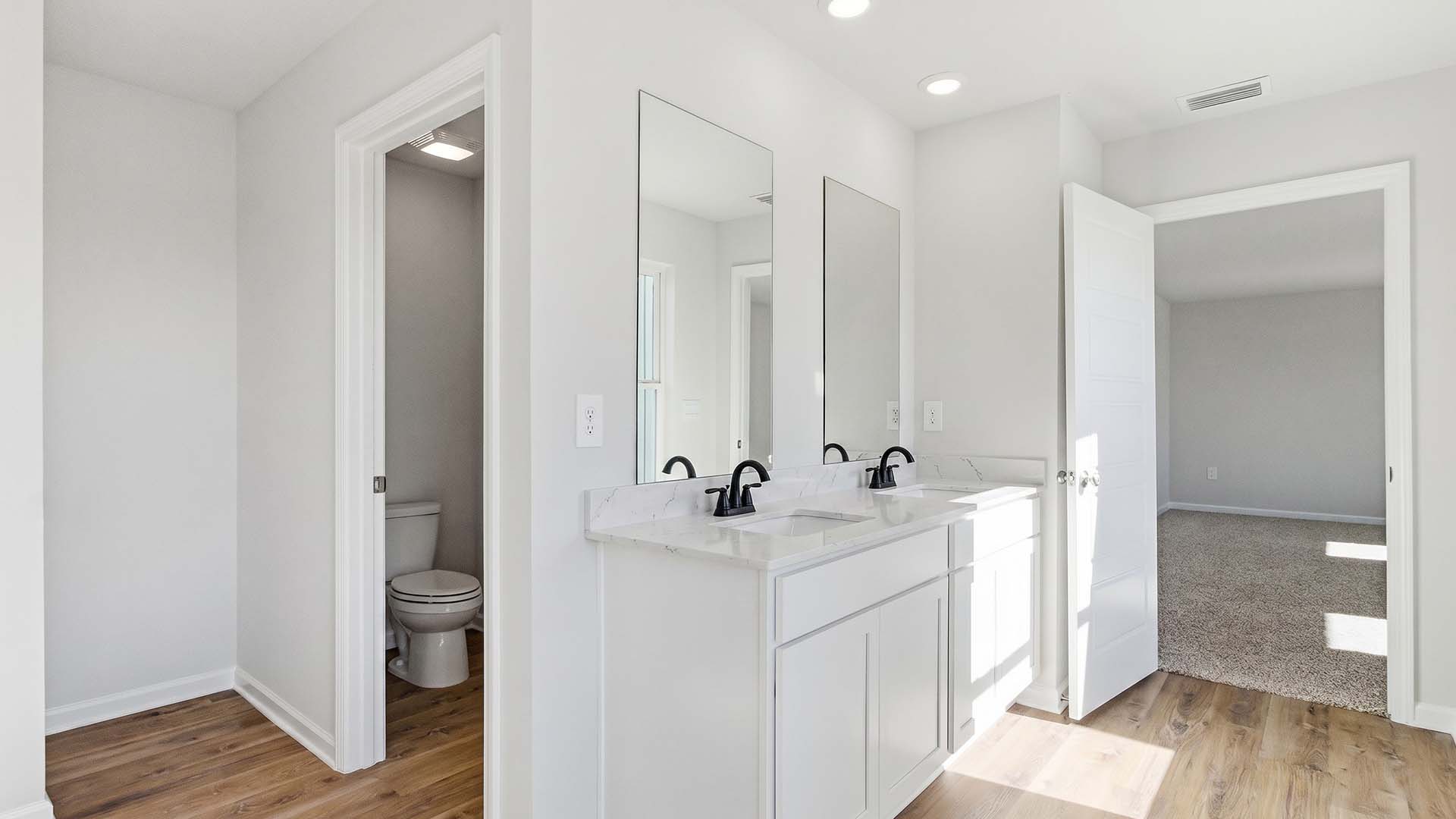 The primary bathroom has quartz countertops and a dual sink vanity