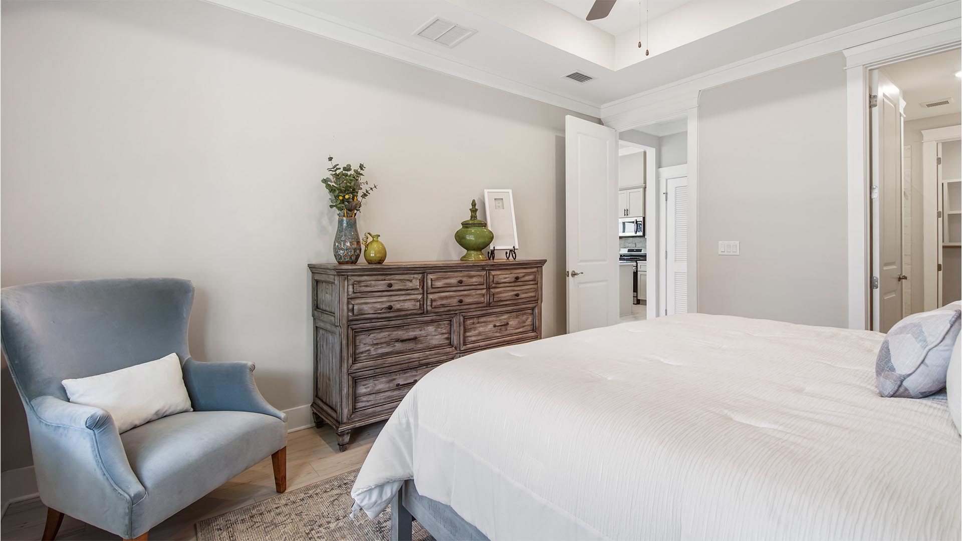 Primary bedroom with EVP flooring and vaulted ceiling and primary bathroom entrance.