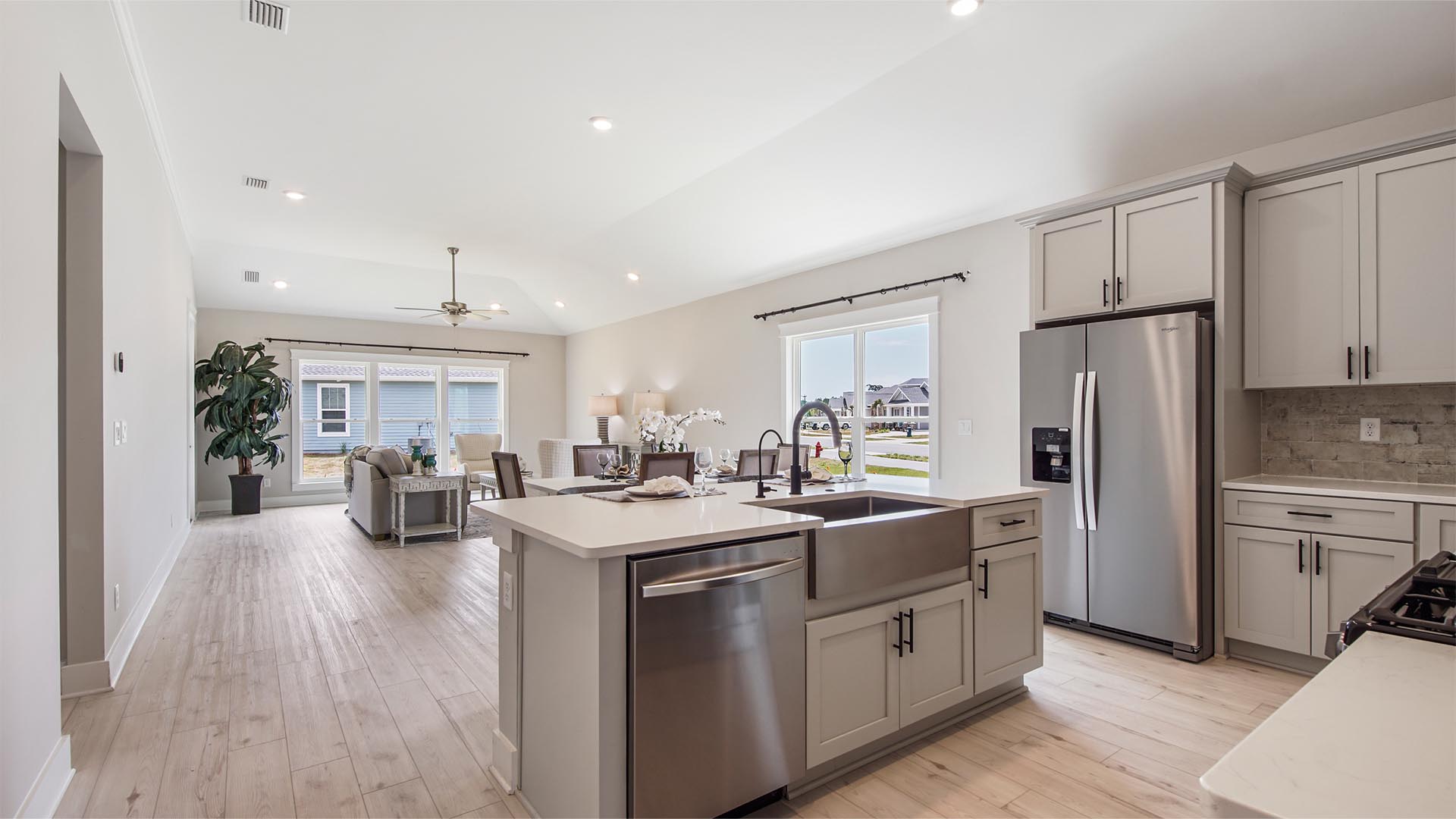 Open concept kitchen with island and quartz countertops and EVP flooring.