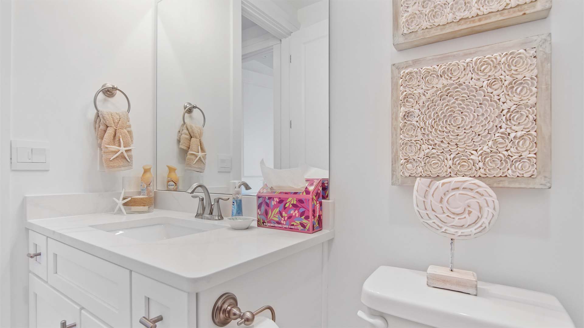 Bathroom two with single vanity with quartz countertops and white cabinetry.