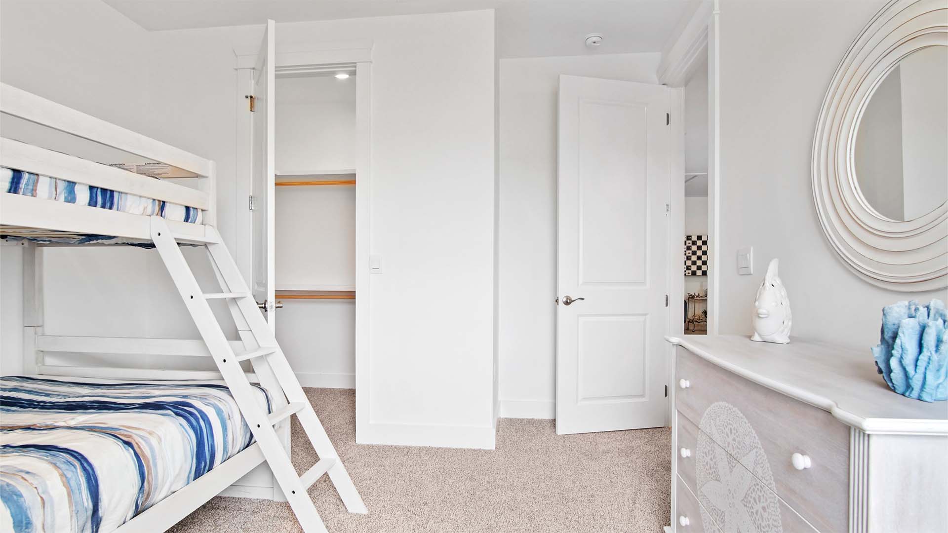 Bedroom three with carpet flooring and a closet with wood shelving.