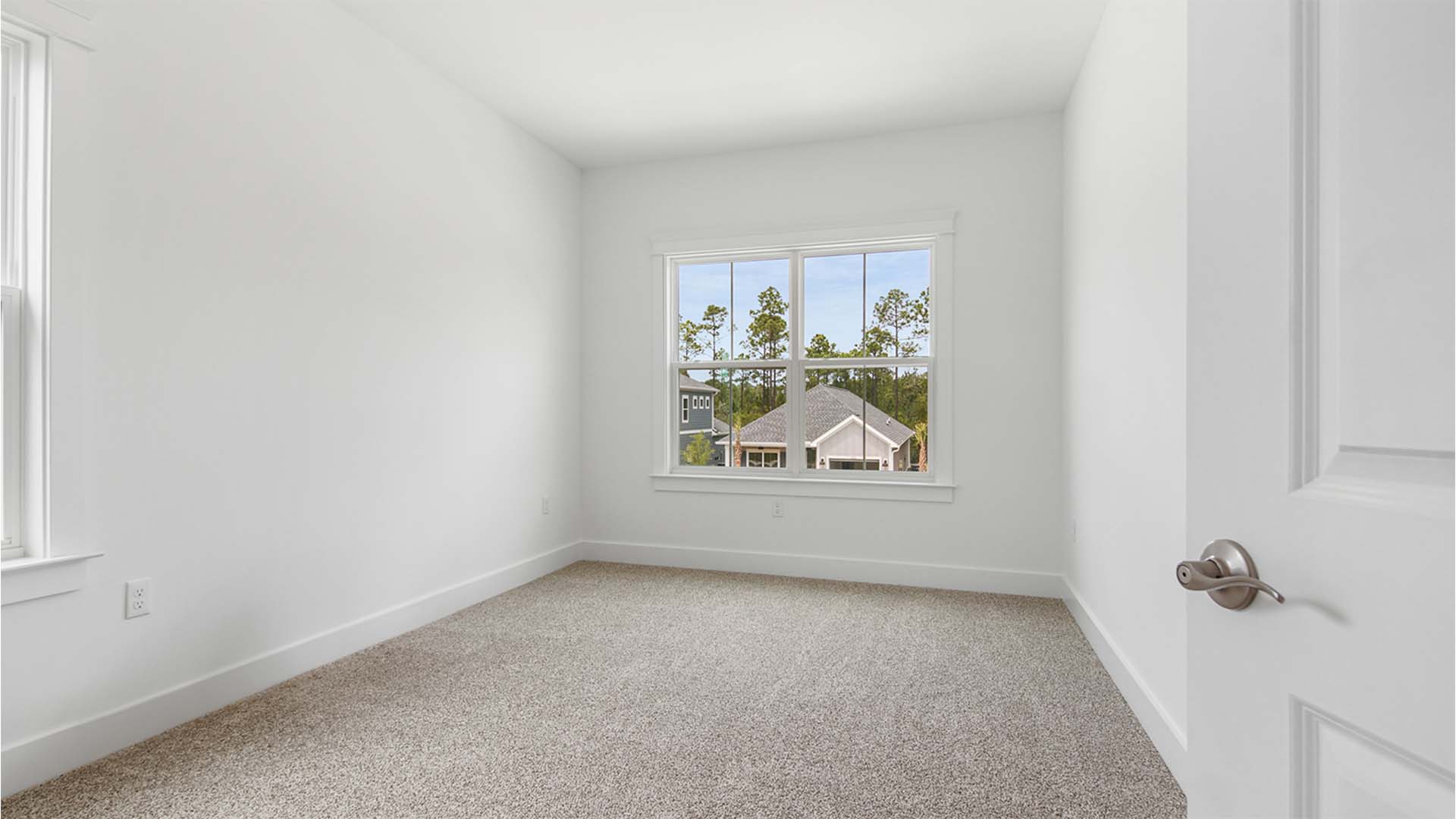 Bedroom four with large windows and carpet flooring.