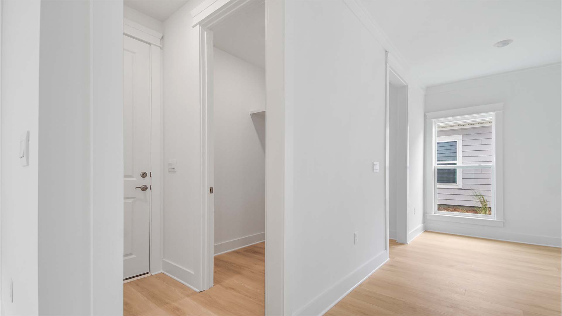 Primary bedroom entrance next to hallway to laundry room and garage.