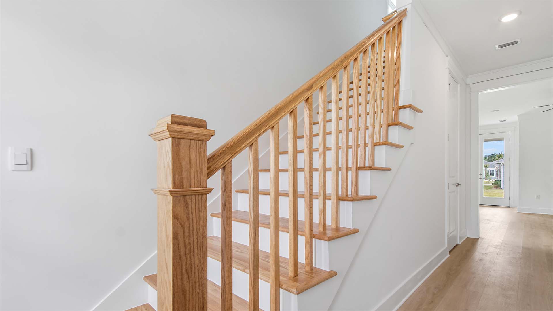 Stairs with wood treads and matching wooden handrail.