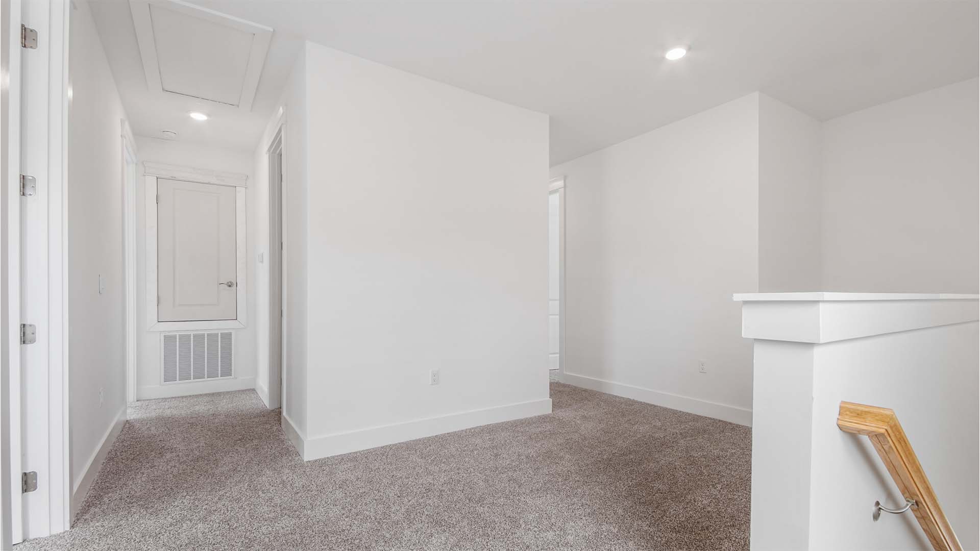 Upstairs landing with carpet flooring and hallways to guest bedrooms.
