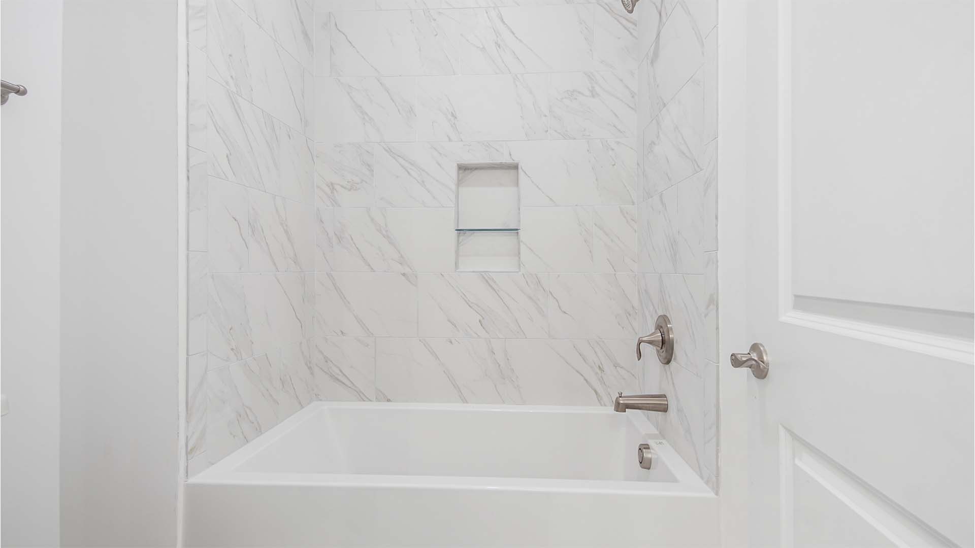 Bathroom three shower room with tub shower with tile walls.