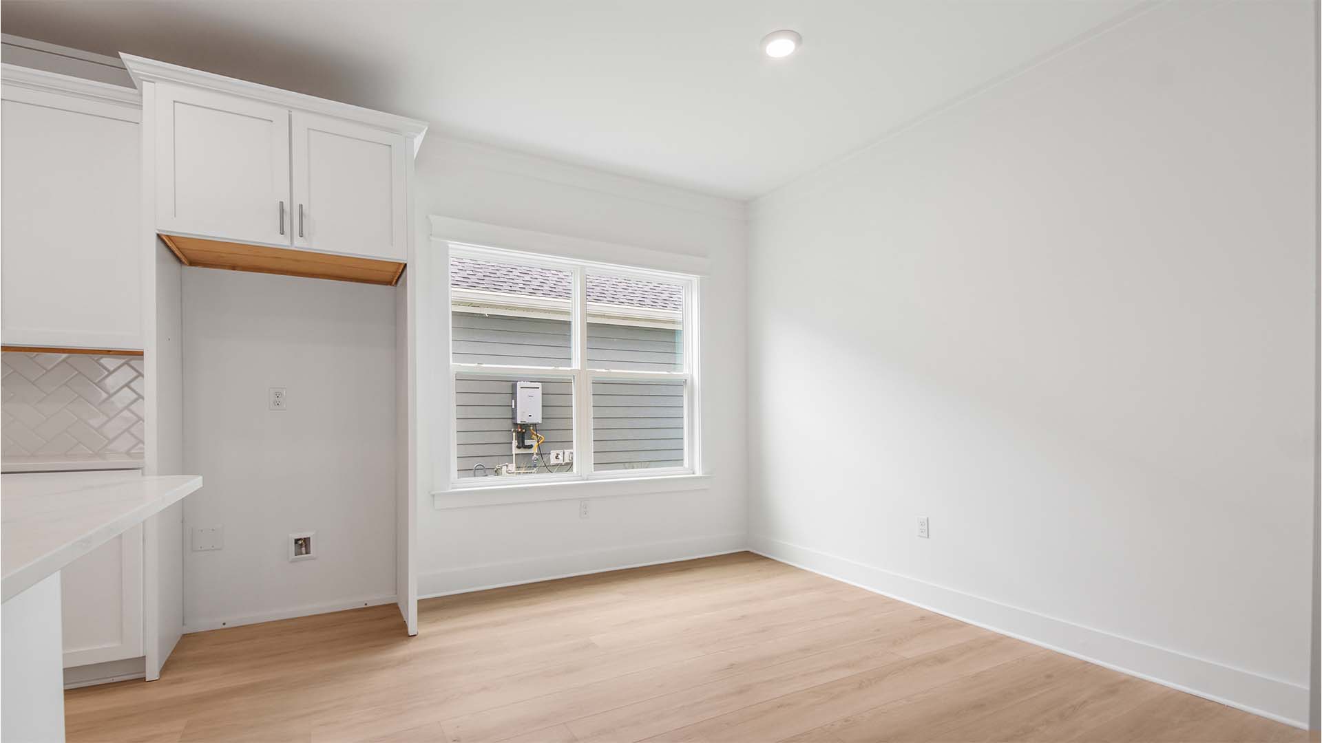 Dining area next to kitchen with large window and EVP flooring.