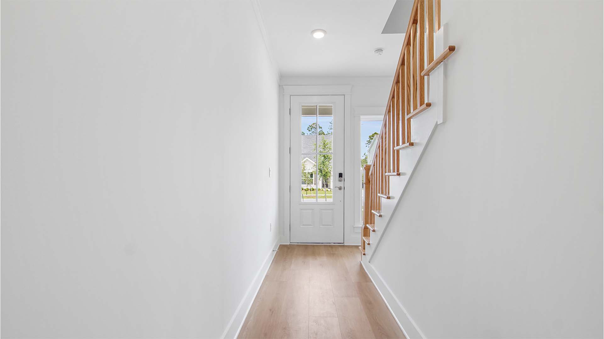 Foyer with EVP flooring and window and front door with window and stairs to second floor.