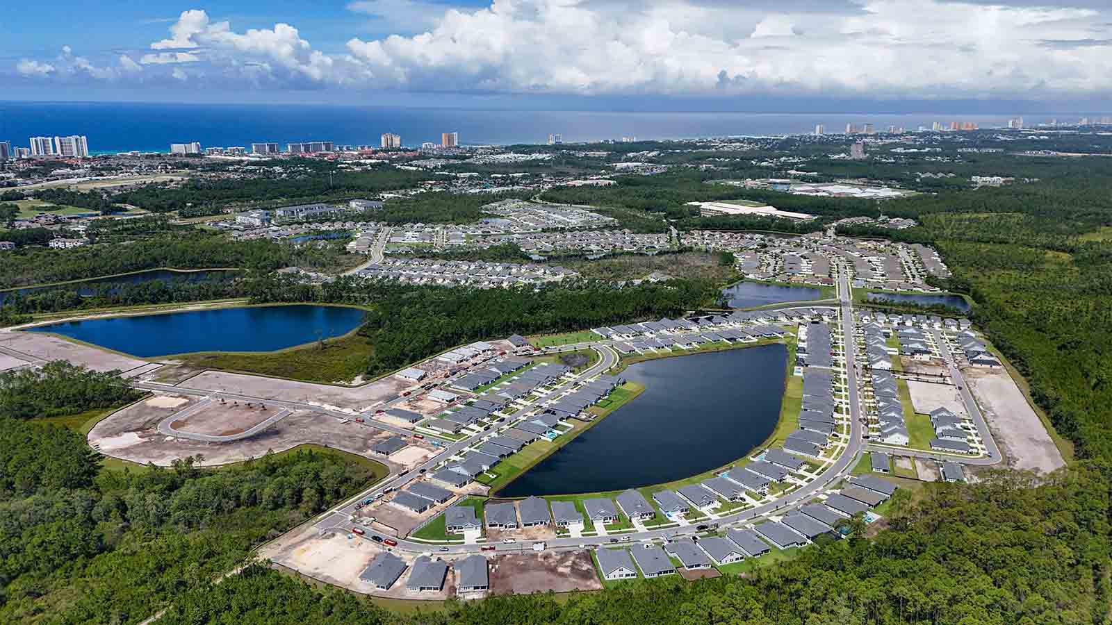 Aerial view of Breakfast Point showing homes and ponds and the Gulf of Mexico.