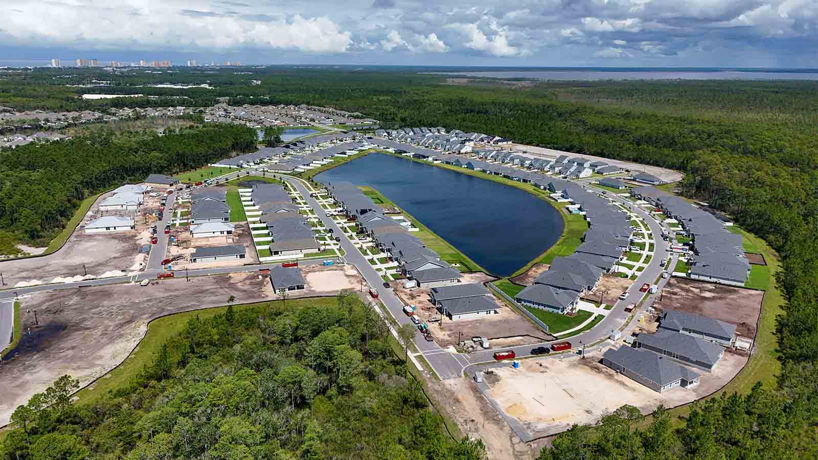 Aerial view of Breakfast Point showing homes and ponds and surrounded by trees.