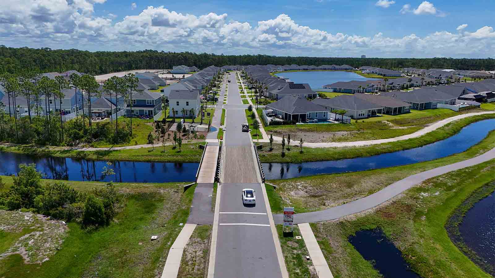 Aerial view of Breakfast Point showing homes and a bridge going over a pond.