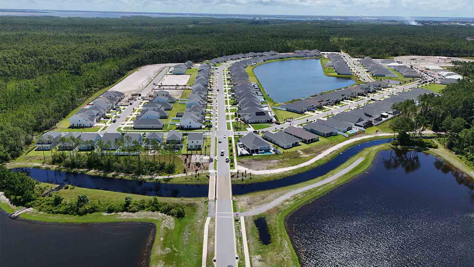 Aerial view of Breakfast Point showing homes and various ponds and a bridge going over a pond.