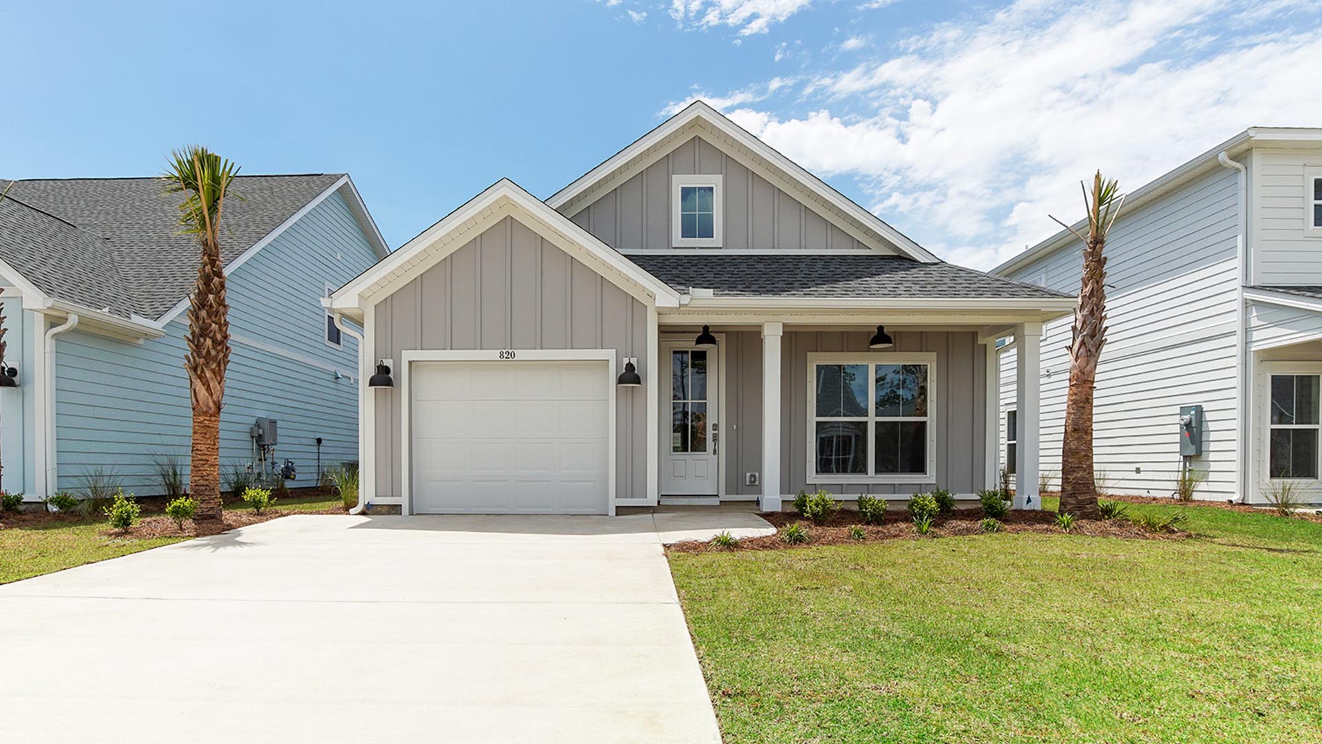 Breakfast Point Bluewater plan front of one story home with large front window and covered front patio and one car garage.