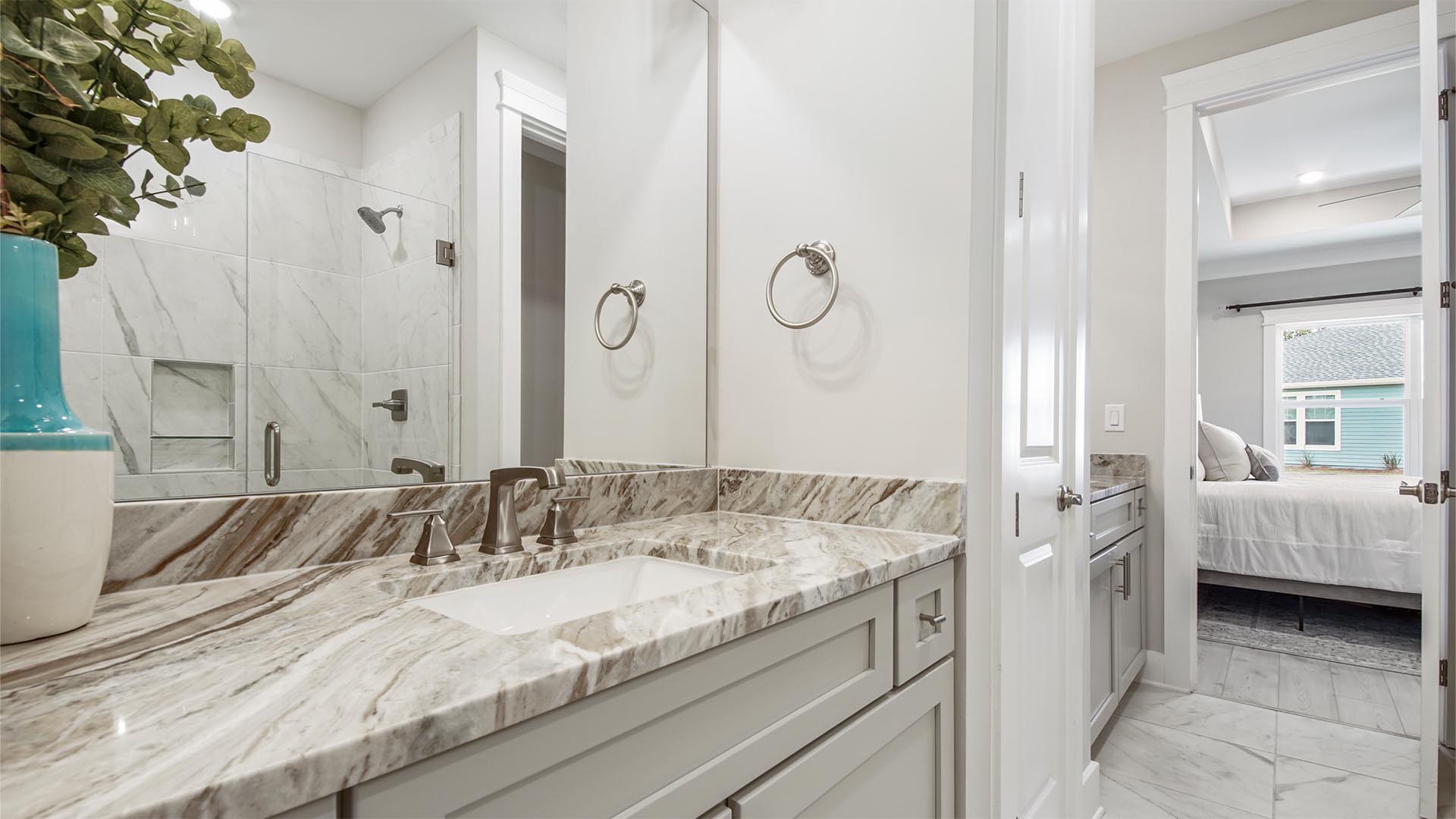 Breakfast Point Bluewater plan primary bathroom with two vanities and quartz countertops and tile floor.