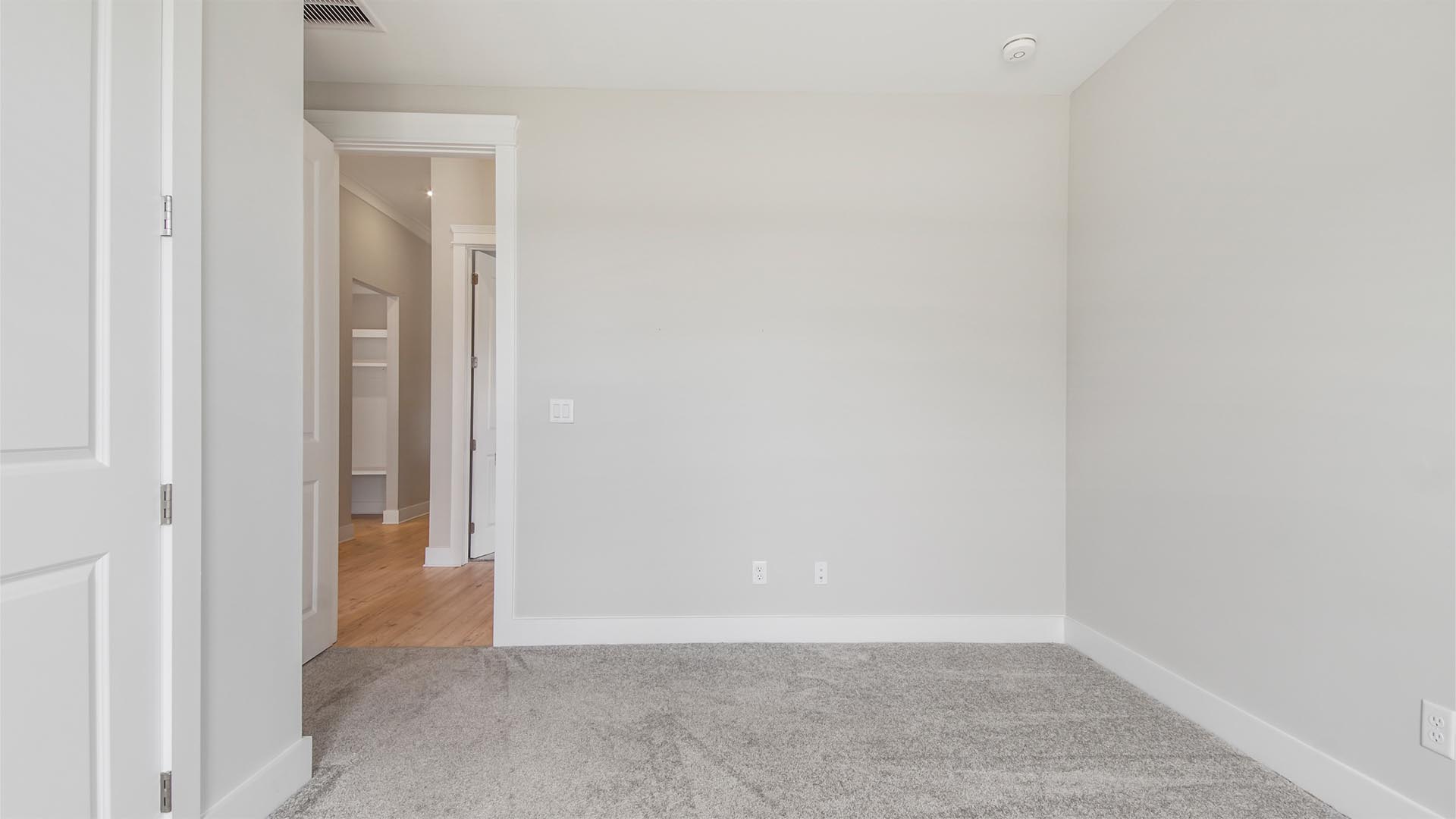 Bedroom two with carpet flooring and double door closet.