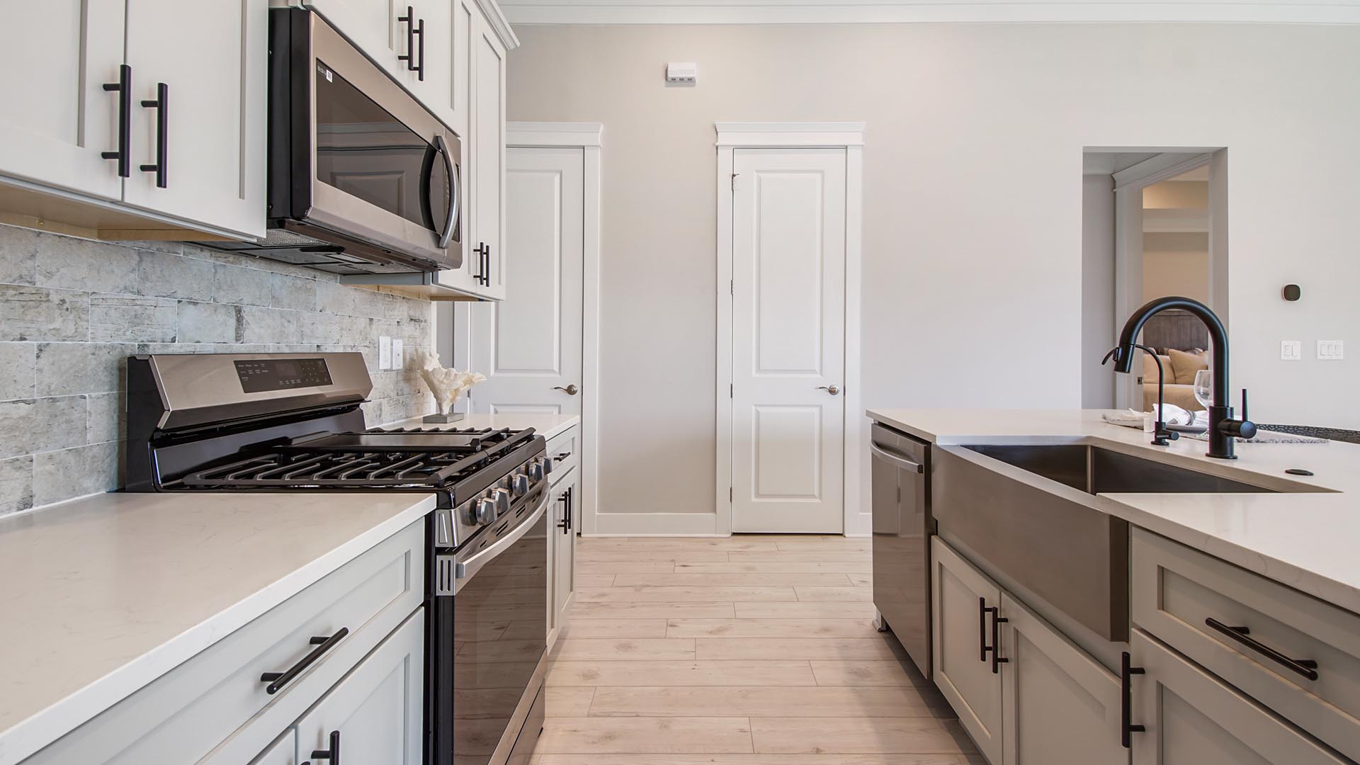 Open concept kitchen with island and quartz countertops and stainless-steel appliances and EVP flooring.