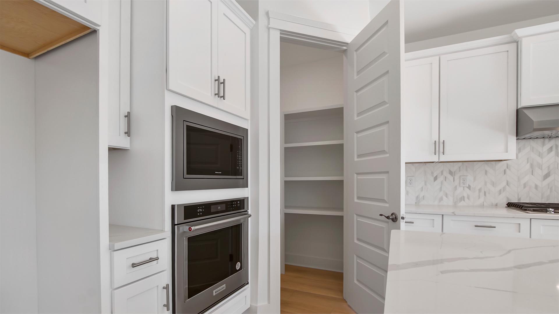 The kitchen has a spacious pantry with wood shelving