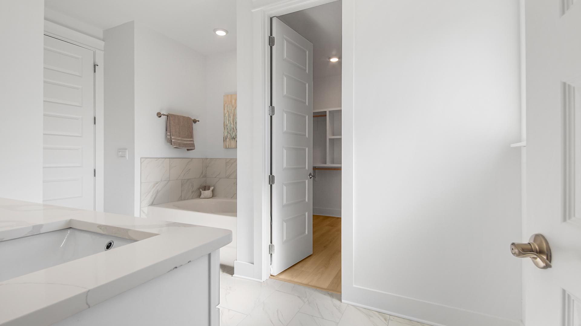 The primary bathroom features beautiful quartz countertops and tile floors