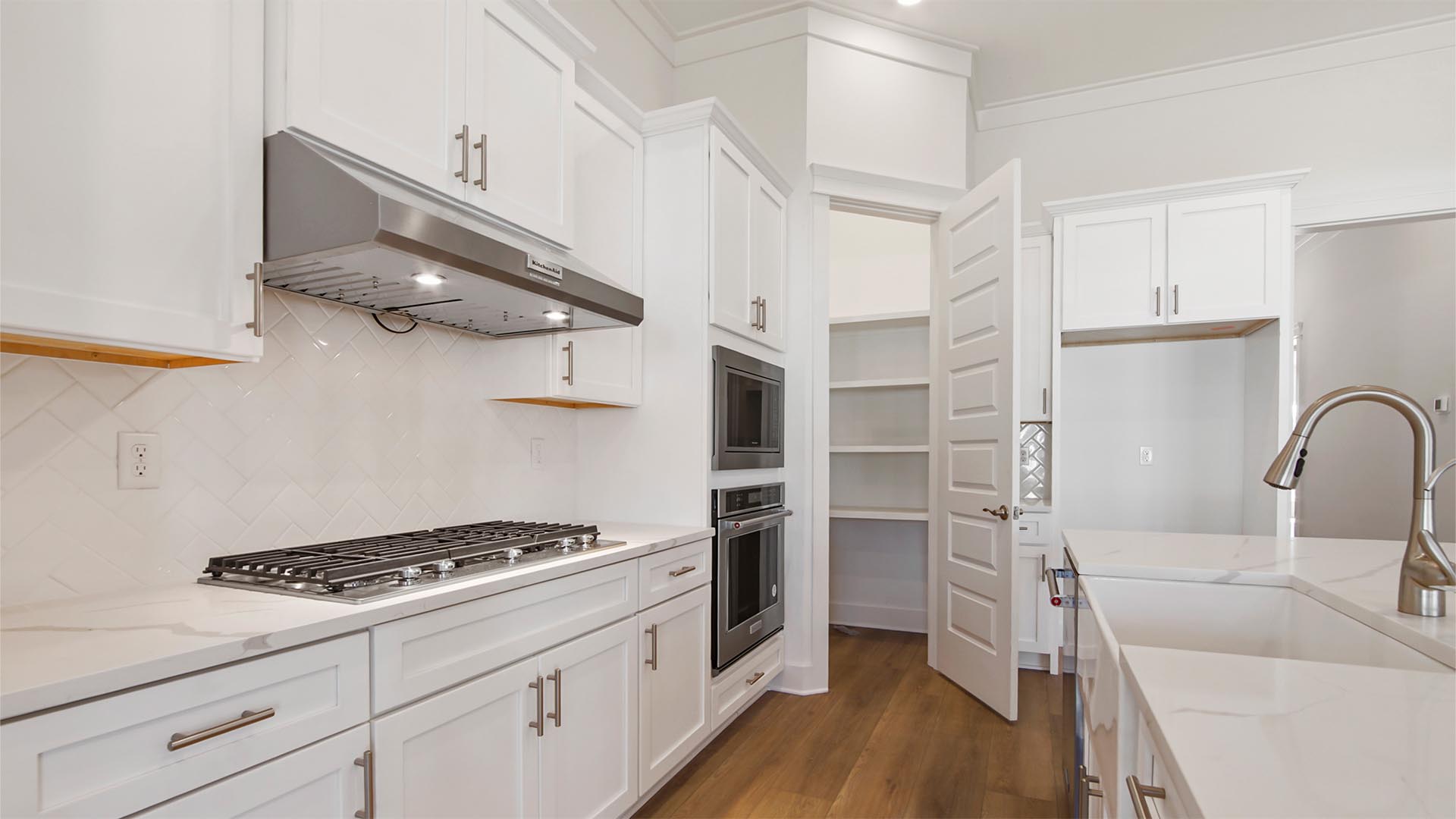 The pantry has wood shelving with plenty of space for dry storage and countertop appliances