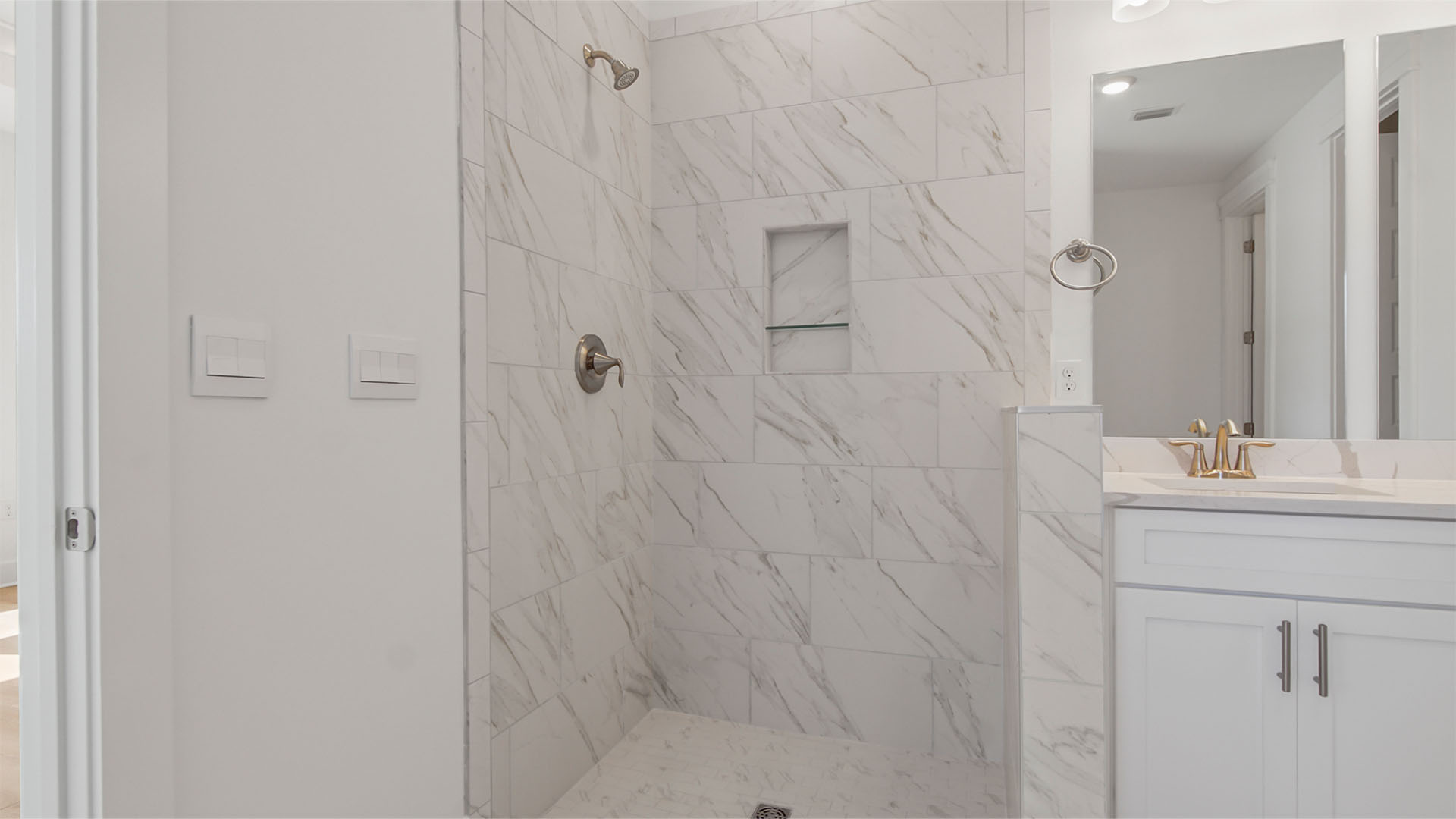 Primary bathroom with marbled tile zero entry shower.