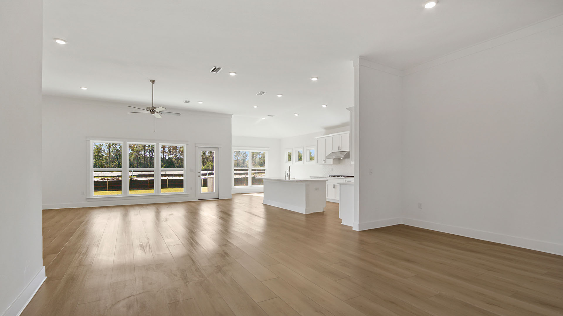 Opening living area with large windows and EVP flooring and open kitchen and dining area and breakfast nook.