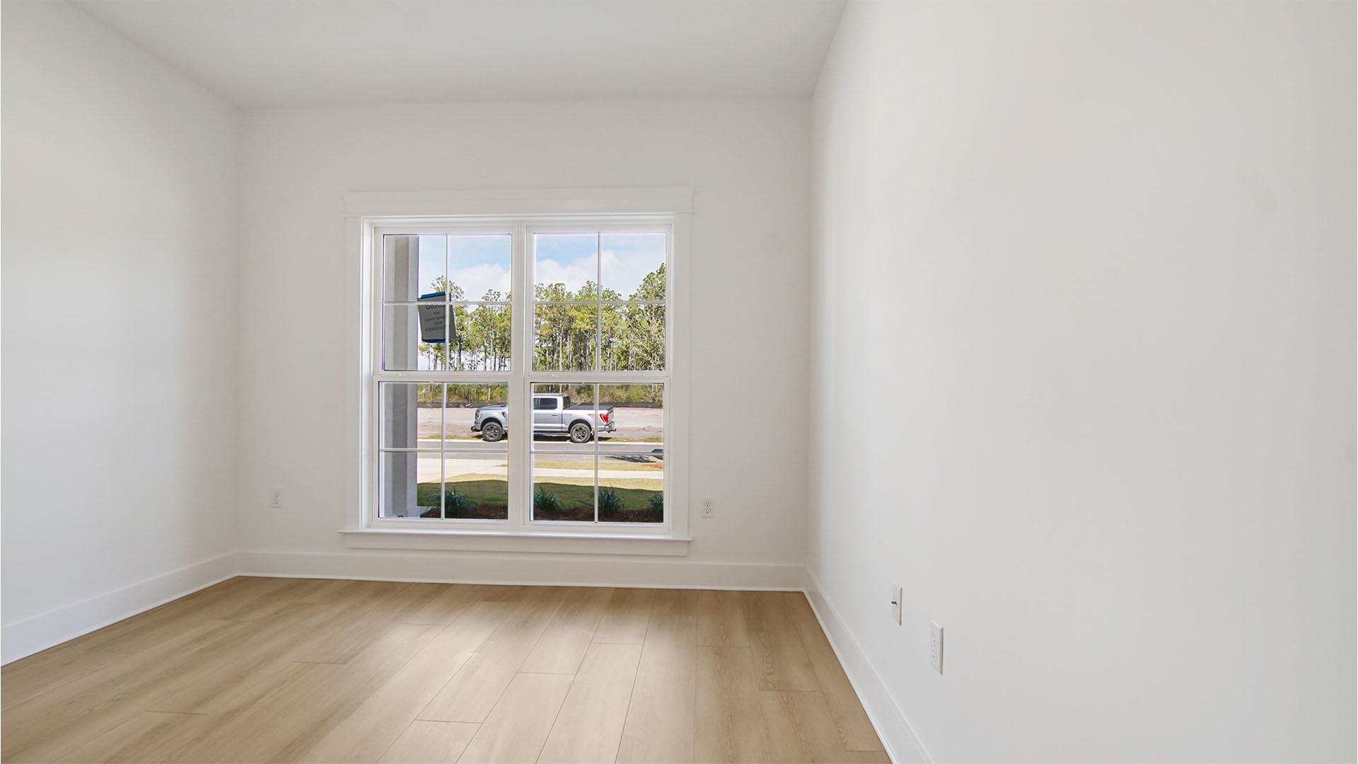 Bedroom two with EVP flooring and large windows.