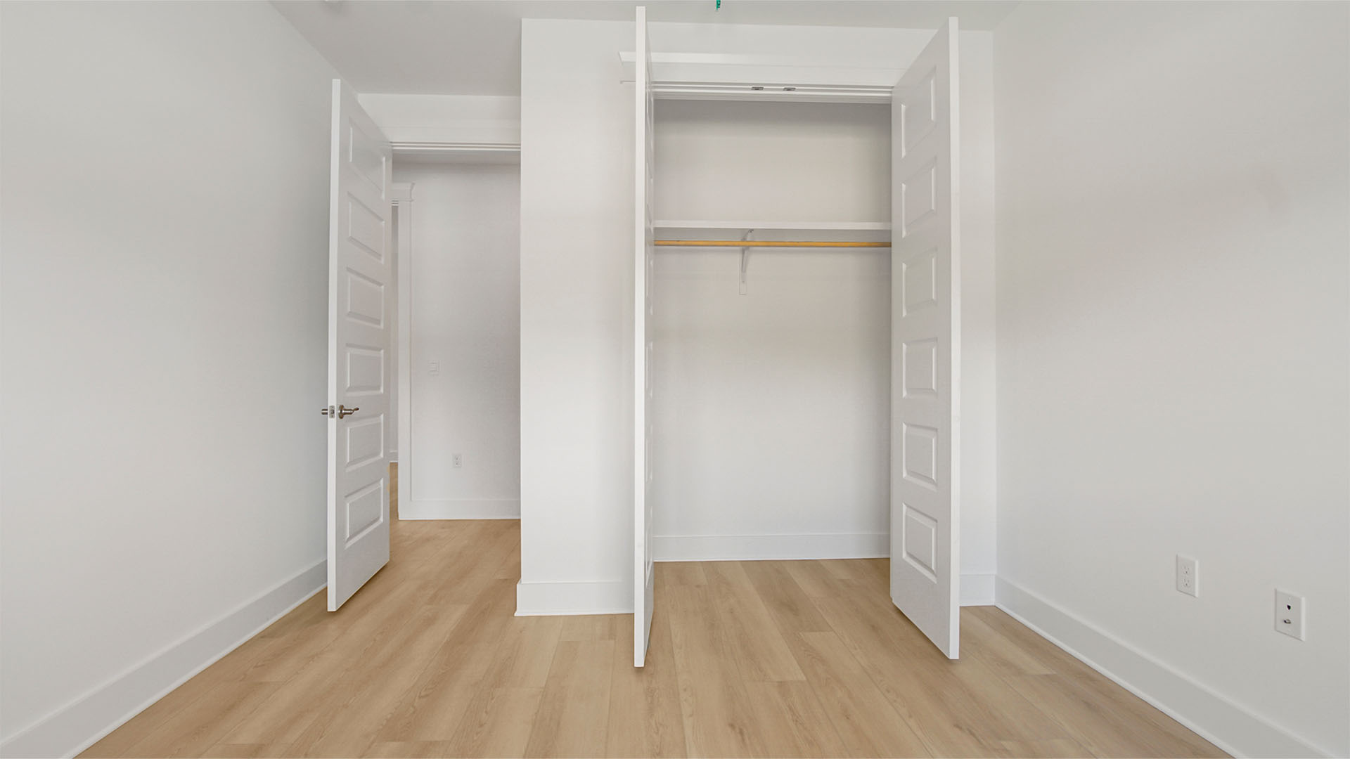 Bedroom two with EVP flooring and double door closet with wooden shelving.