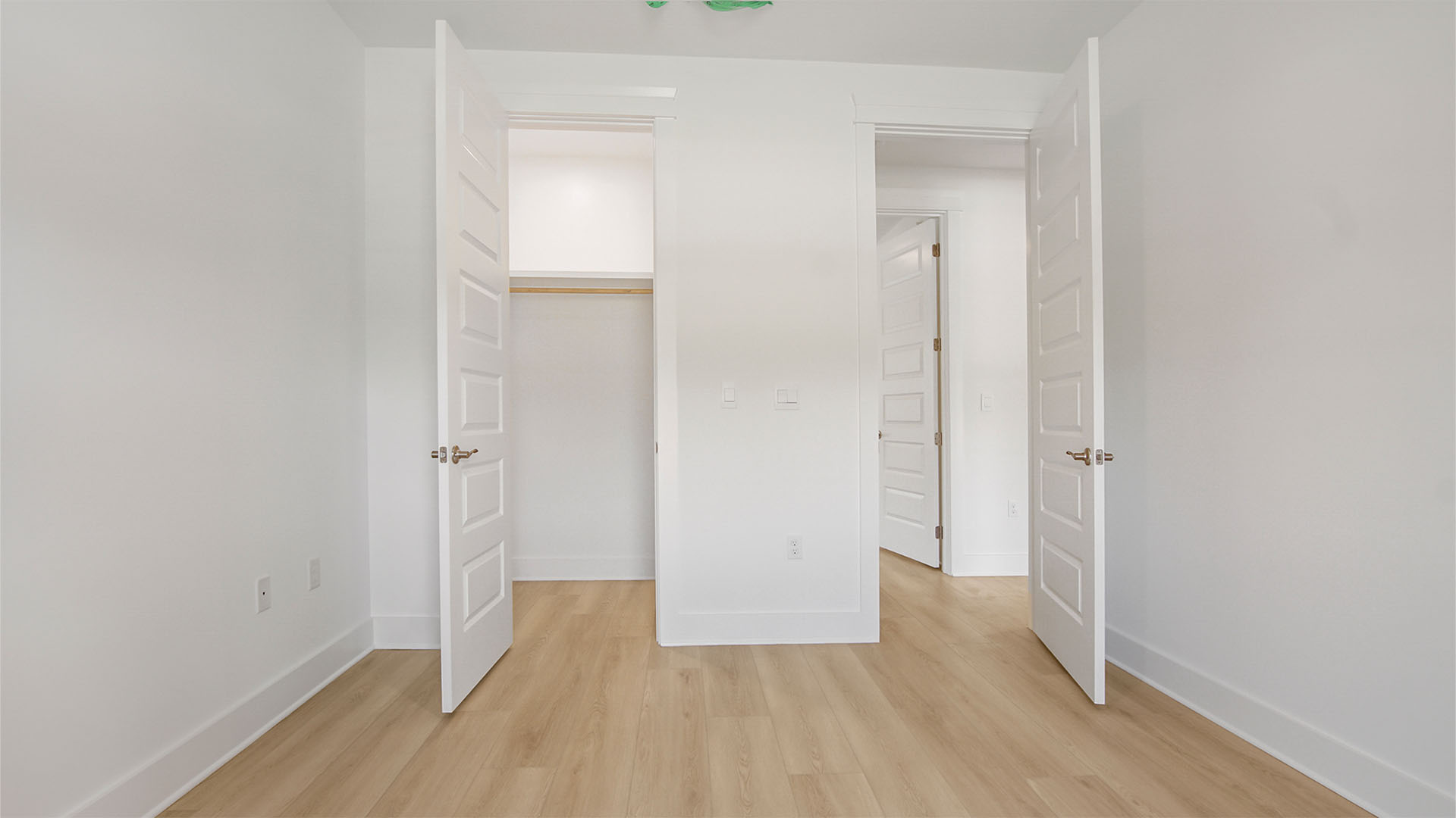 Bedroom three with EVP flooring and closet with wooden shelving.