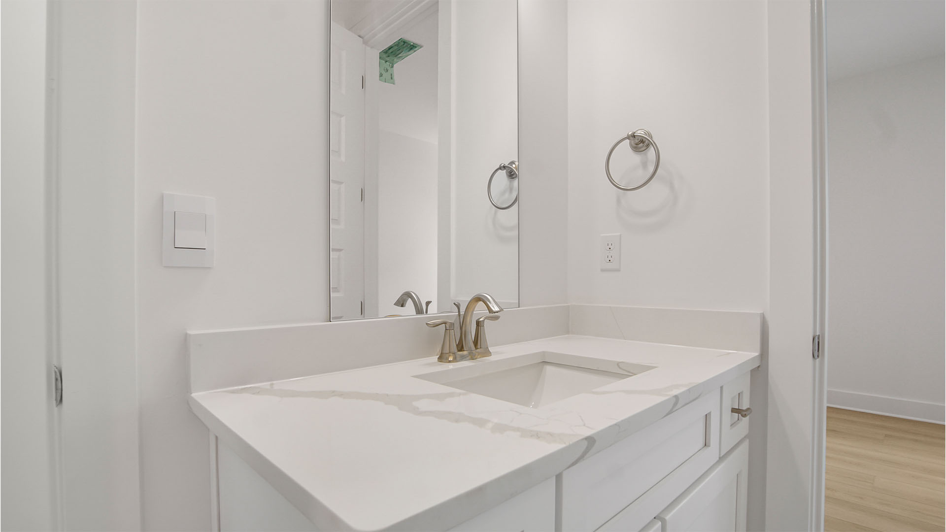 Bathroom two with vanity with quarts countertops and white cabinetry.