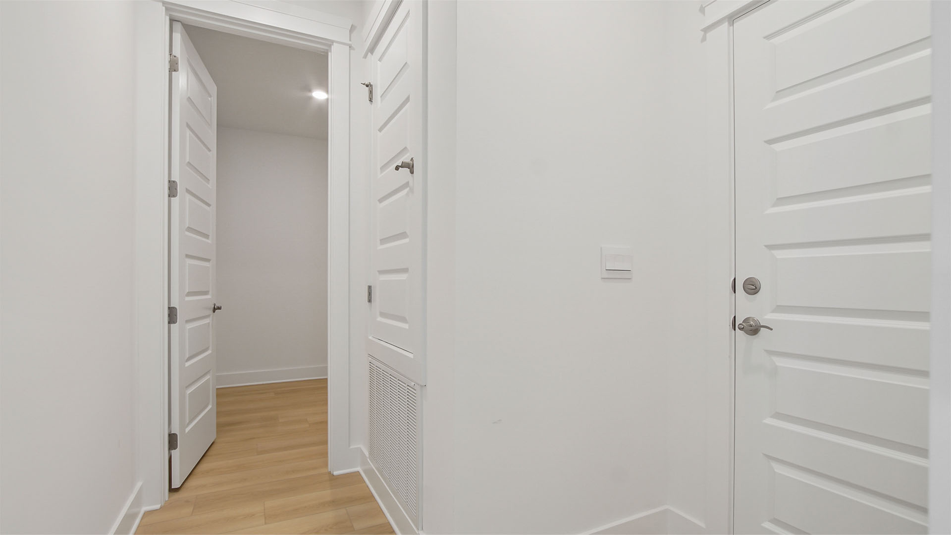 Hallway with laundry room and garage door.